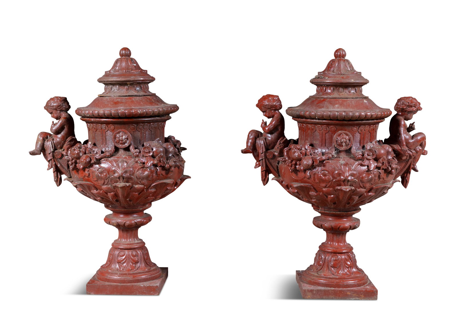 A PAIR OF CAST IRON AND RED PAINTED GARDEN URNS, c.98cm high (two putti partially detached): A PAIR OF CAST IRON AND RED PAINTED GARDEN URNS, c.98cm high (two putti partially detached)