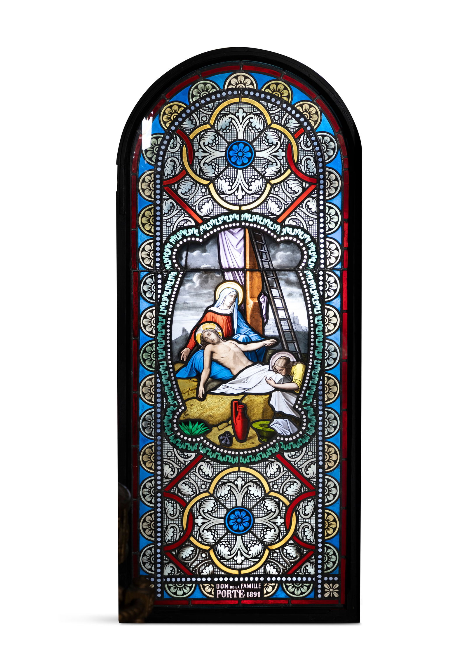 A FRENCH 19TH CENTURY STAINED GLASS AND LEAD FRAMED WINDOW, depicting the deposition of Christ,: A FRENCH 19TH CENTURY STAINED GLASS AND LEAD FRAMED WINDOW, depicting the deposition of Christ, with the Virgin Mary and Mary Magdalene, arched form, in blue, green, red, tones, inscribed 'Don de la F