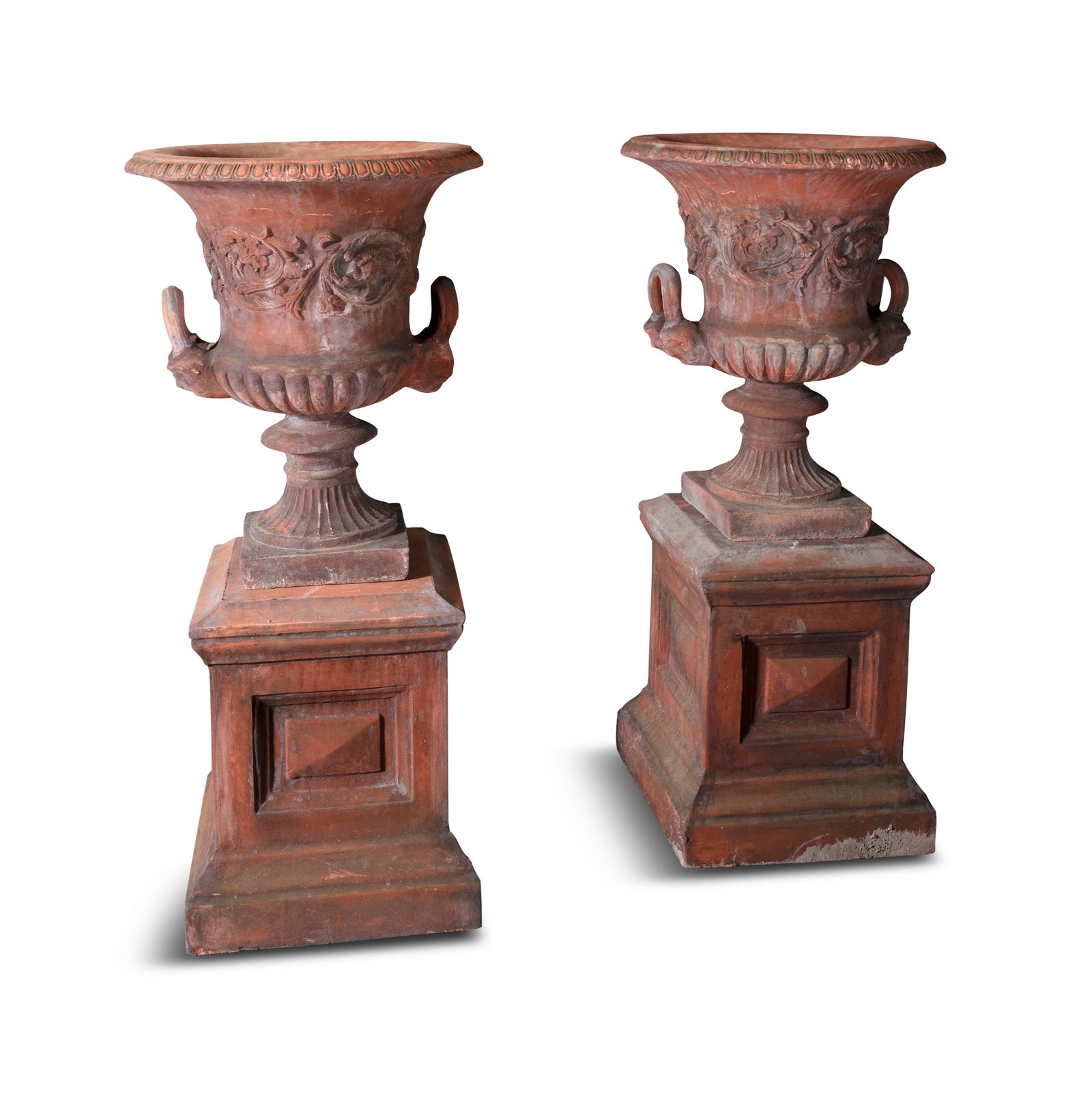 A PAIR OF COMPOSITE RED PAINTED STONE URNS, Campagna form, out turned rims, egg-and-dart moulding,: A PAIR OF COMPOSITE RED PAINTED STONE URNS, Campagna form, out turned rims, egg-and-dart moulding, bodies decorated with scrolling foliage, mask handles, demi fluted on waisted socle, square bases 80c