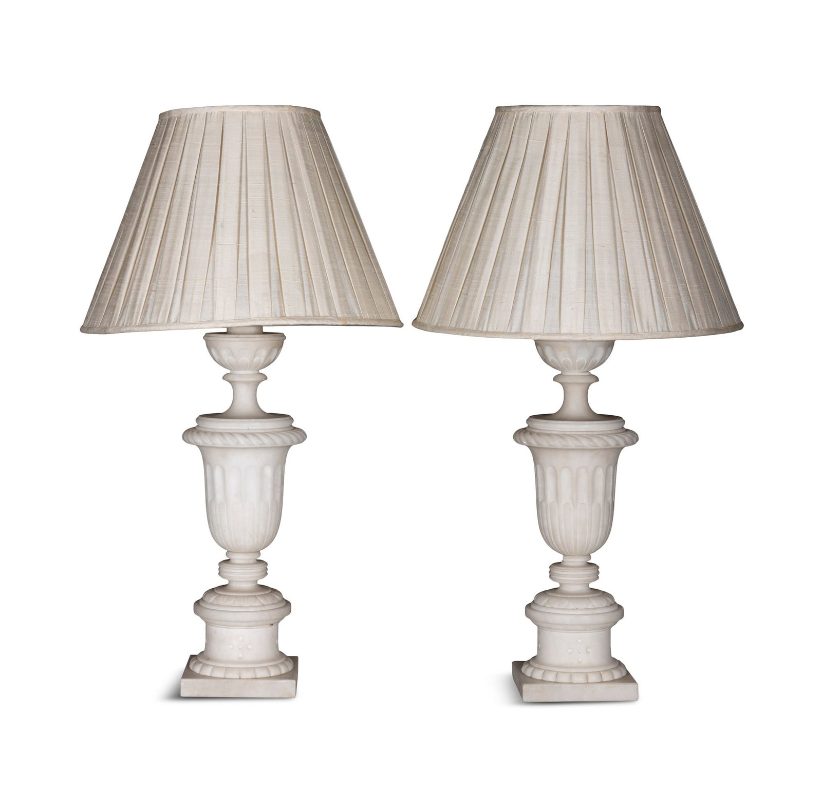 A PAIR OF ALABASTER URNS CONVERTED TO TABLE LAMPS, of Campagna form, on stepped circular bases. c. (1 of 2)