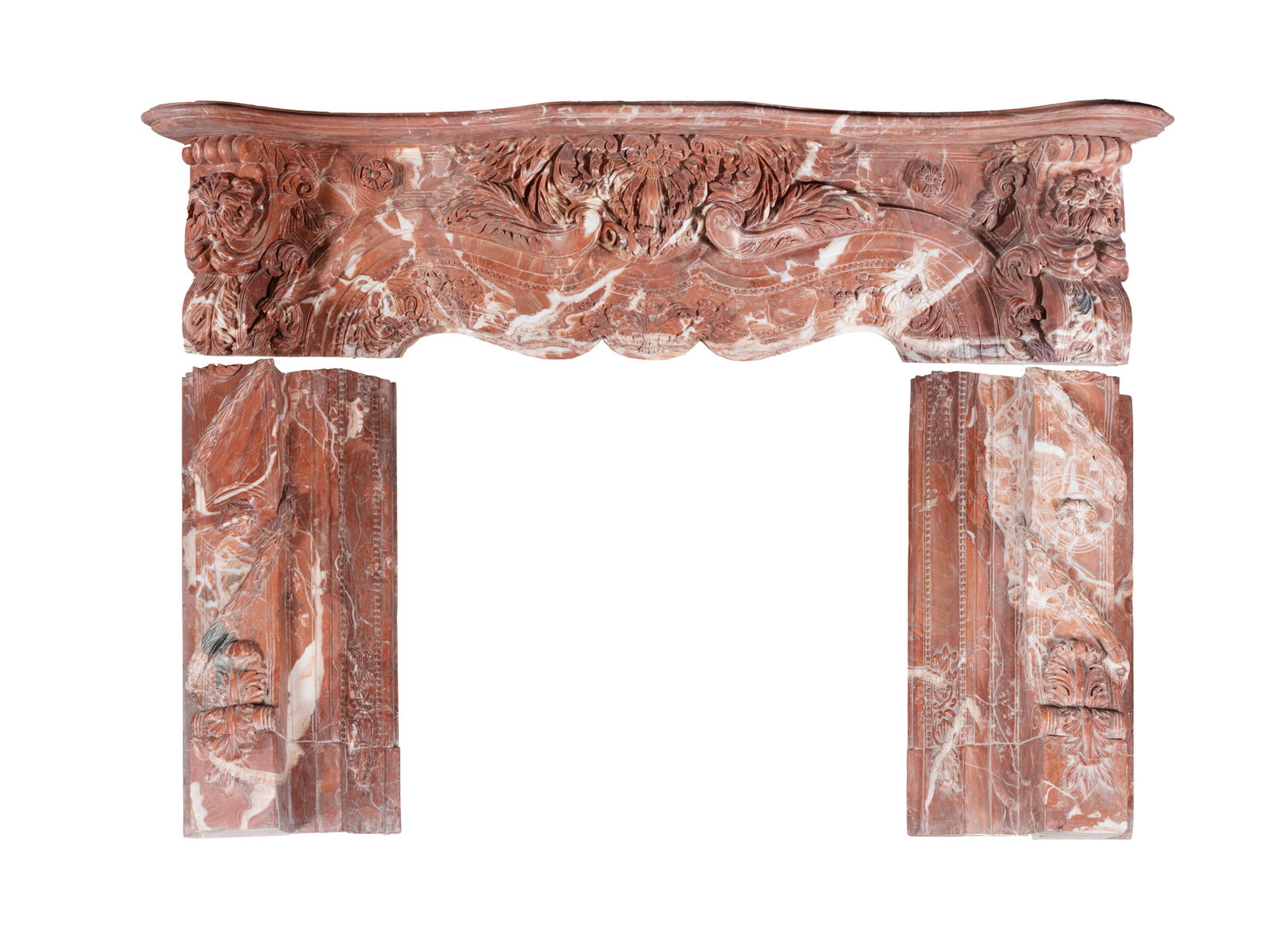A MODERN VARIEGATED ROUGE MARBLE MONUMENTAL FIREPLACE, the mantel over a profusely carved frieze of: A MODERN VARIEGATED ROUGE MARBLE MONUMENTAL FIREPLACE, the mantel over a profusely carved frieze of scrolled corbels, decorated with acanthus leaves, rosettes, on short column supports. 128cm high