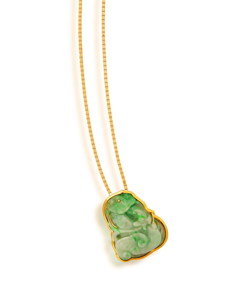 A JADE PENDANT ON CHAIN • A carved jade plaque • box-link chain • mounted in 18K (1 of 2)