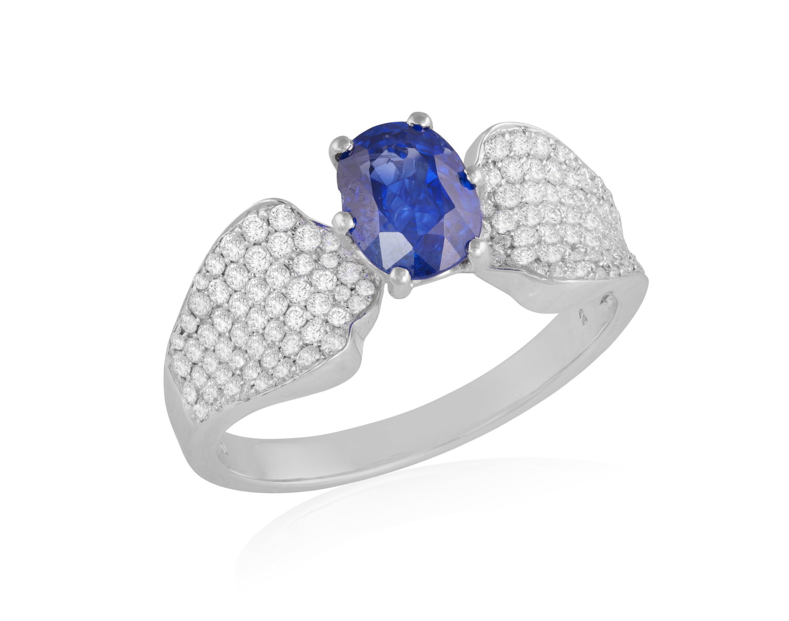 A SAPPHIRE AND DIAMOND RING • Set with an oval-shaped sapphire, approx. 1.29cts •: A SAPPHIRE AND DIAMOND RING • Set with an oval-shaped sapphire, approx. 1.29cts • pavé-set brilliant-cut diamond shoulders, of undulating design • mounted in 18K gold • ri