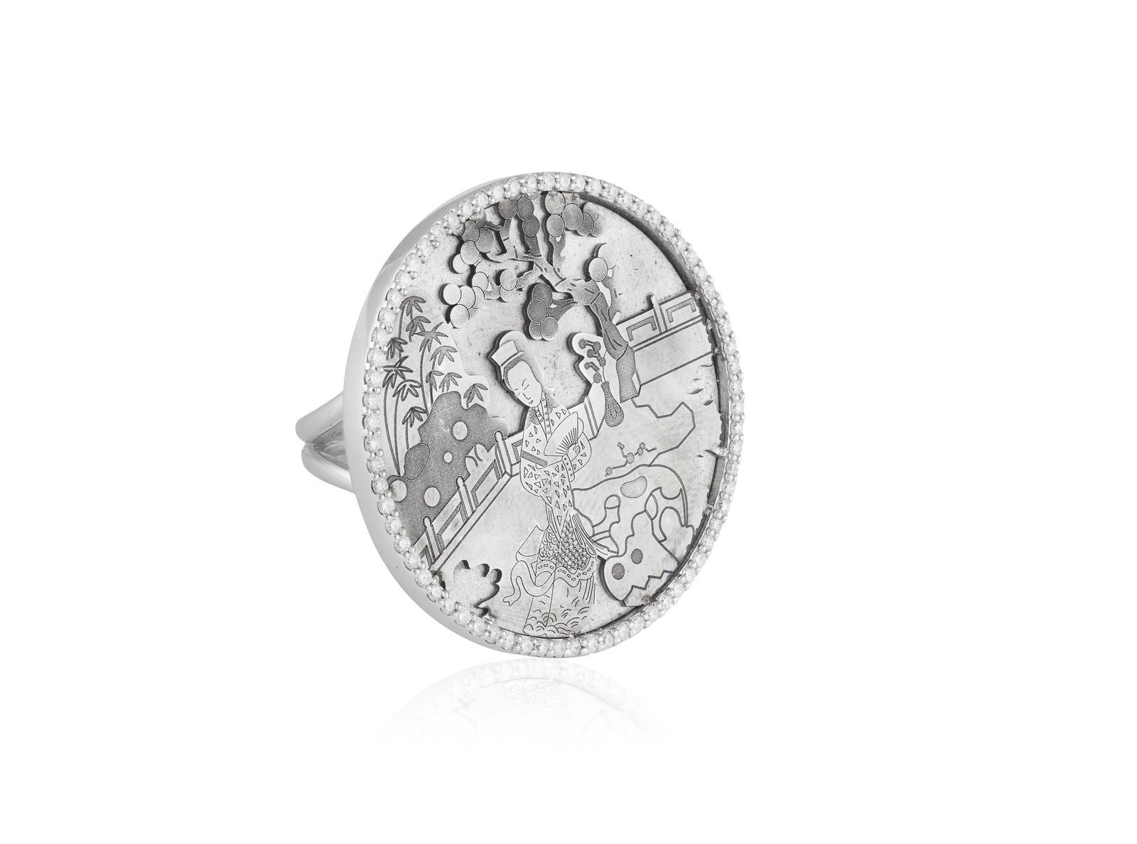 A DIAMOND RING • A large circular plaque with Japanese garden motif • brilliant-cut diam: A DIAMOND RING • A large circular plaque with Japanese garden motif • brilliant-cut diamonds • mounted in 18K gold • signed Yume • ring size N⅓