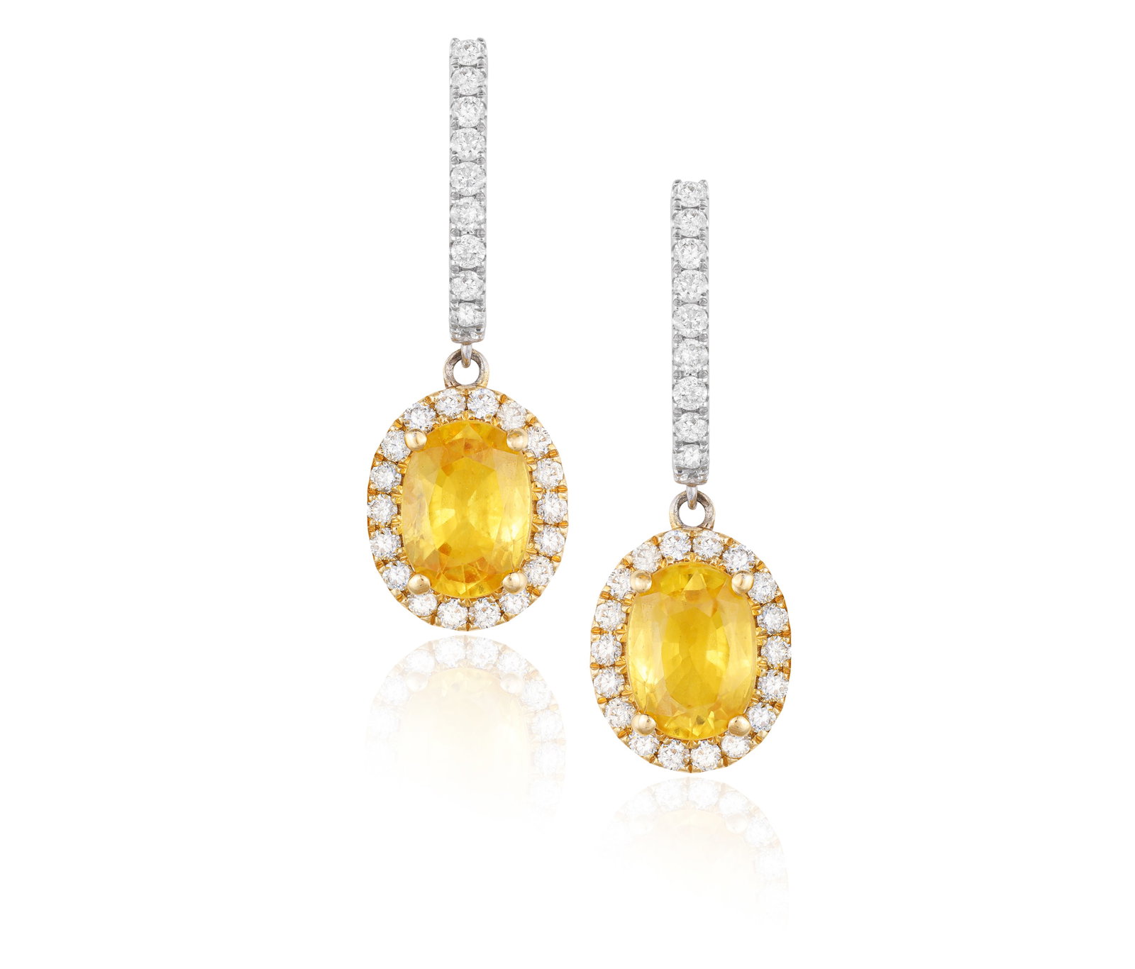 A PAIR OF SAPPHIRE AND DIAMOND PENDENT EARRINGS • Two oval-shaped yellow sapphires, approx. 3.: A PAIR OF SAPPHIRE AND DIAMOND PENDENT EARRINGS • Two oval-shaped yellow sapphires, approx. 3.20cts total • brilliant-cut diamonds • mounted in 18K gold • length 2.8cm