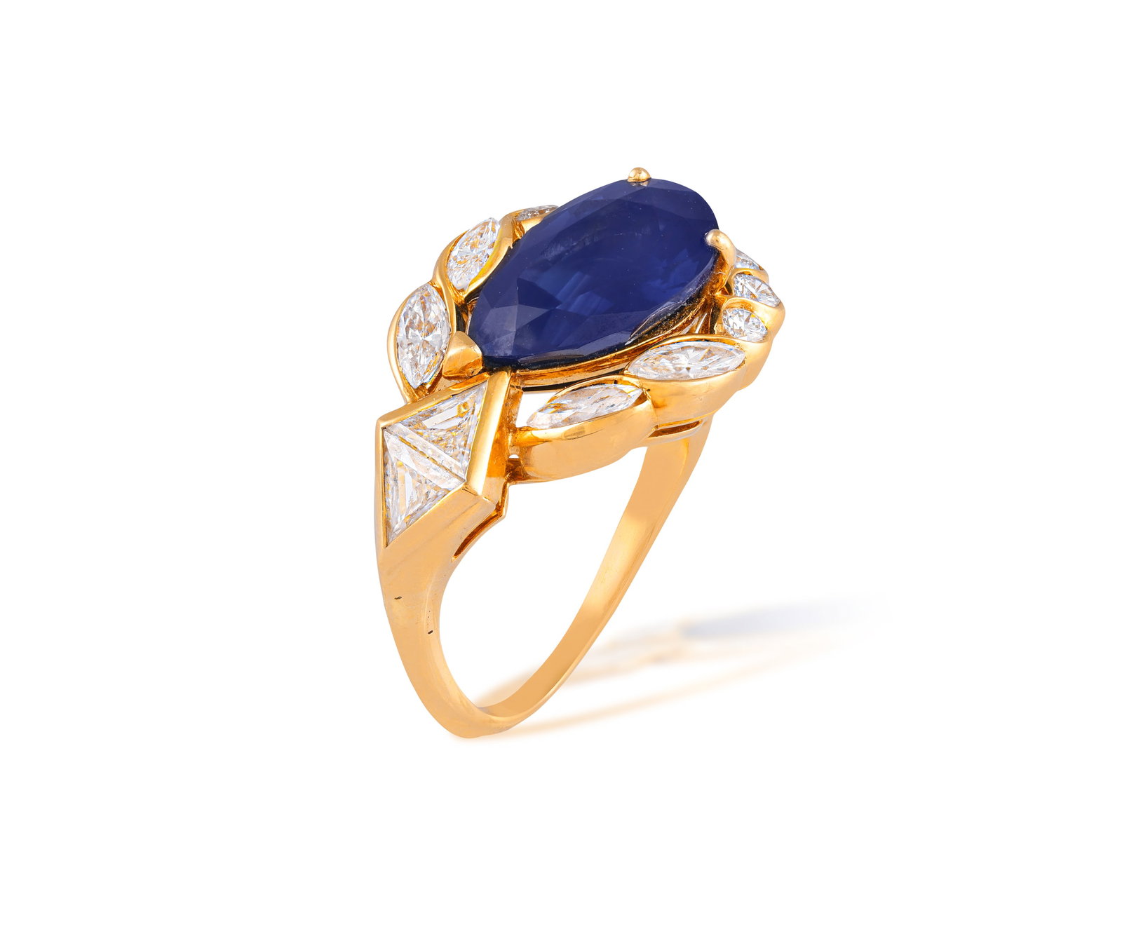 A SAPPHIRE AND DIAMOND DRESS RING, CIRCA 1990 • Pear-shaped sapphire, approx. 6.80cts •: A SAPPHIRE AND DIAMOND DRESS RING, CIRCA 1990 • Pear-shaped sapphire, approx. 6.80cts • brilliant and marquise-shaped diamond surround • trillion-shaped diamond accents • diamo