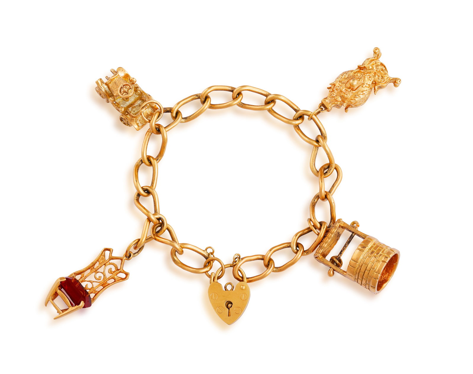 A GOLD CHARM BRACELET • A cable-link chain • suspending four charms • heart-shaped (1 of 3)