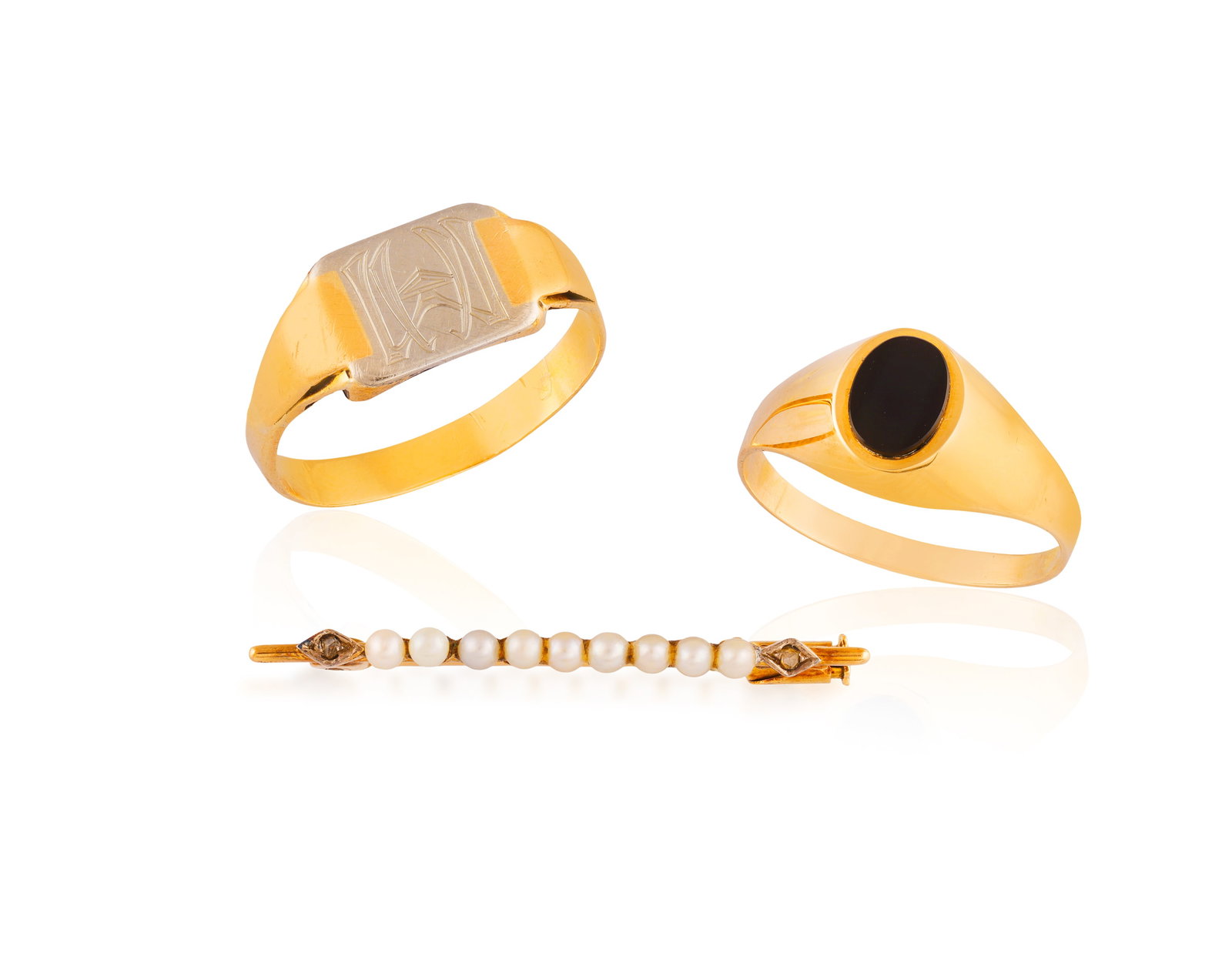 A GROUP OF TWO RINGS AND A BAR BROOCH • A bi-coloured signet with engraved letters 'MH' •: A GROUP OF TWO RINGS AND A BAR BROOCH • A bi-coloured signet with engraved letters 'MH' • mounted in 18K gold • with partial maker's mark • ring size S; An oval-shaped onyx rin