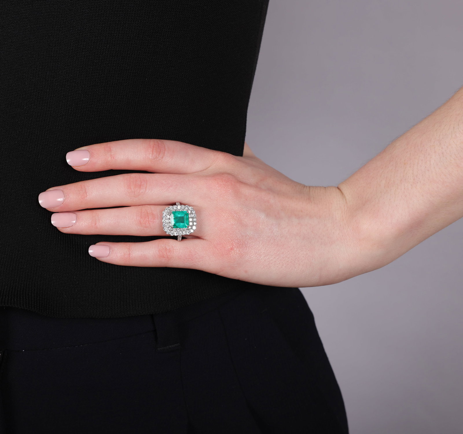 AN EMERALD AND DIAMOND CLUSTER RING • Rectangular-shaped emerald, approx. 3.00cts • - 3