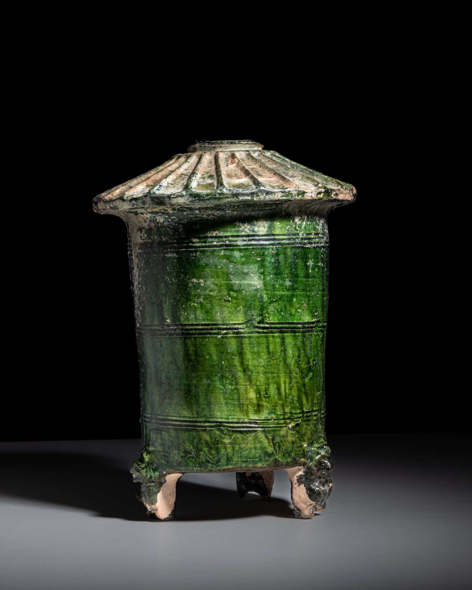 A GREEN -GLAZED POTTERY 'GRANARY' JAR 汉代 绿釉陶谷仓: A GREEN -GLAZED POTTERY 'GRANARY' JAR 汉代 绿釉陶谷仓 Han Dynasty (206 BC – 220 AD) H.31cm - D.23cm The vessel is sturdily potted in the form of a cylin