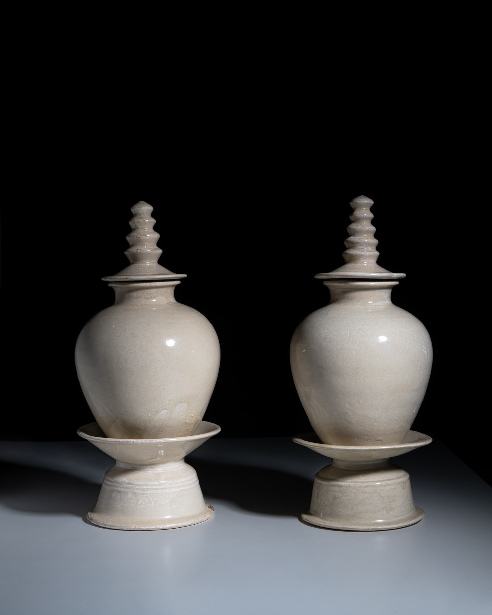 AN EXTREMELY RARE PAIR OF BUDDHIST WHITE-GLAZED 'PAGODA-SHAPED' COVERED JARS WITH STANDS 唐 (1 of 3)