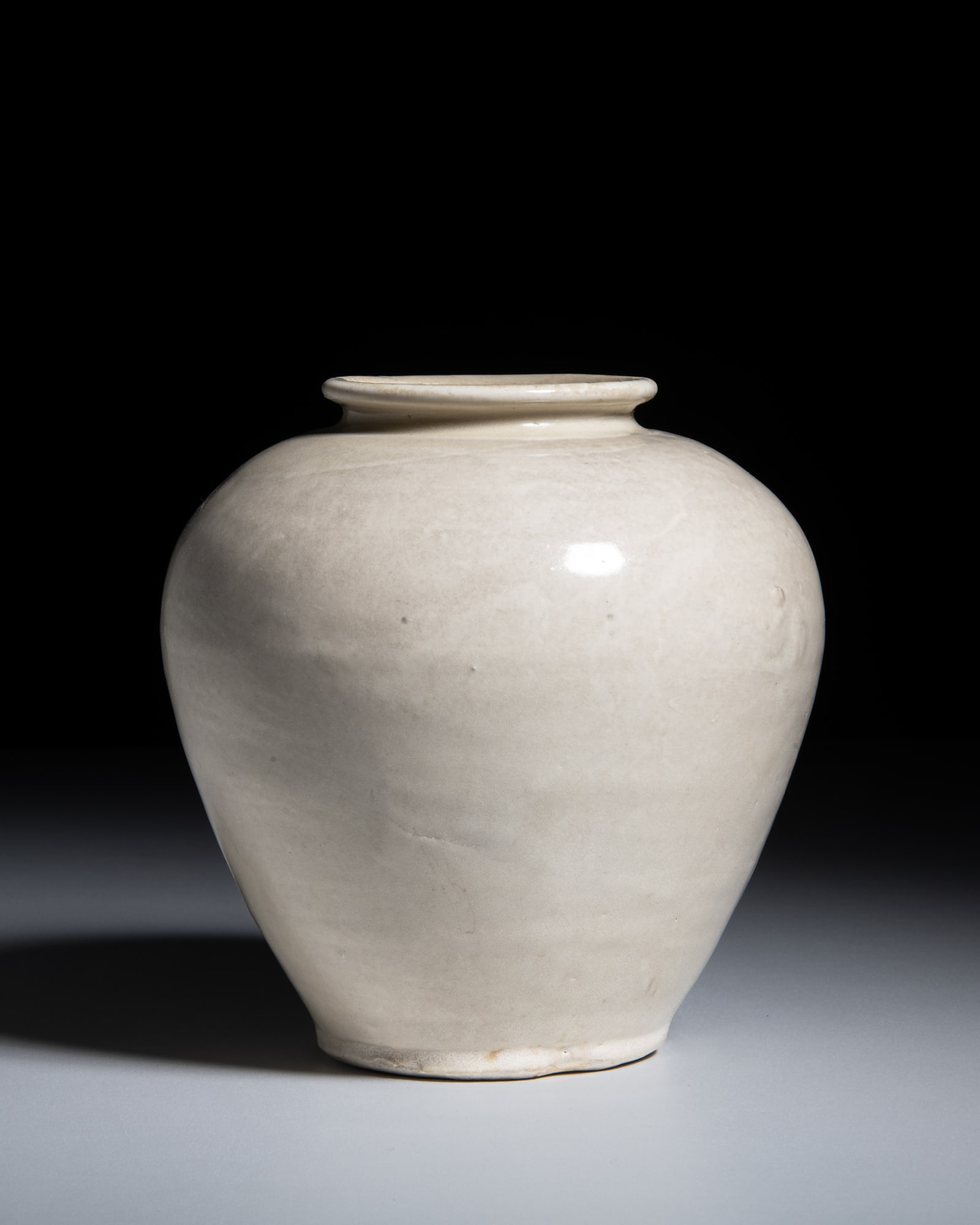 A RARE XING WARE WHITE-GLAZE JAR 唐 邢窑白釉罐 China, Tang: A RARE XING WARE WHITE-GLAZE JAR 唐 邢窑白釉罐 China, Tang dynasty (618–907) H.15.6cm Finely potted with a robust, ovoid body rising from a flat base to a sho