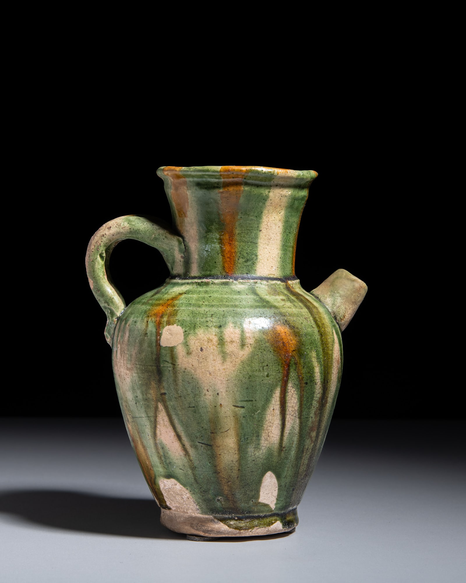 A SANCAI GLAZED HANDLED EWER 唐代 三彩执壶 China, Tang: A SANCAI GLAZED HANDLED EWER 唐代 三彩执壶 China, Tang dynasty (618-907) H.17.5cm Provenance: A Paris art instructor’s collection