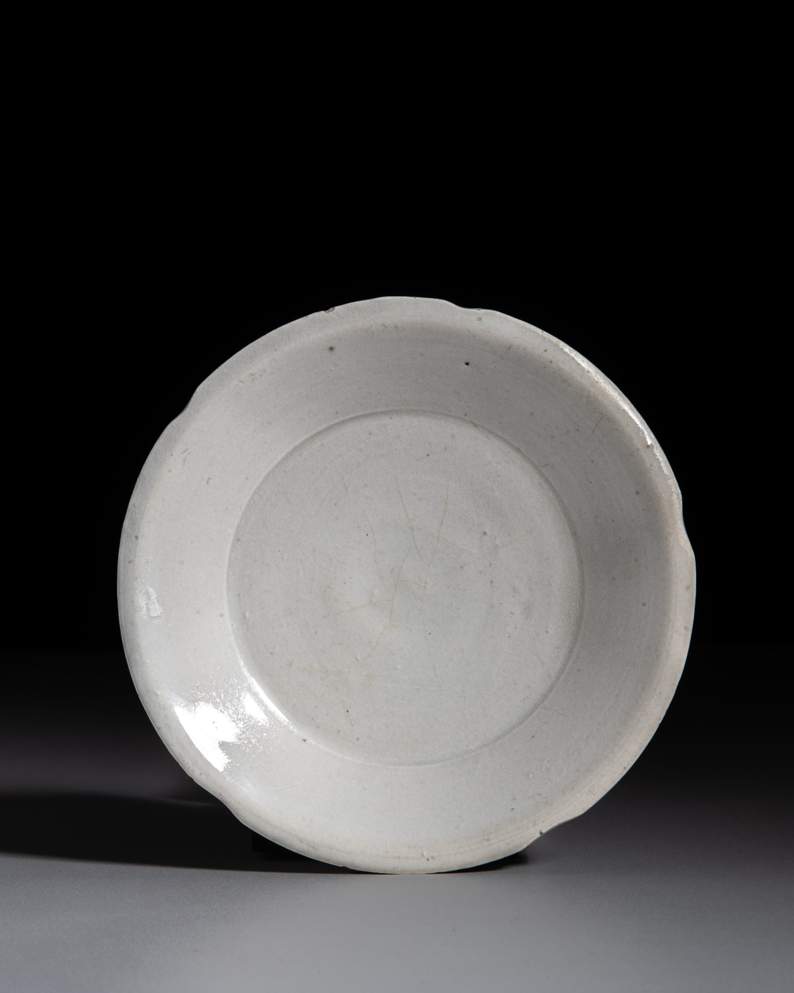 A SMALL DING WARE WHITE GLAZED LOBED DISH 宋代 定窑花口小: A SMALL DING WARE WHITE GLAZED LOBED DISH 宋代 定窑花口小碟 China, Song dynasty (960-1279) D.13.1cm Provenance: -A Paris art instructor’s