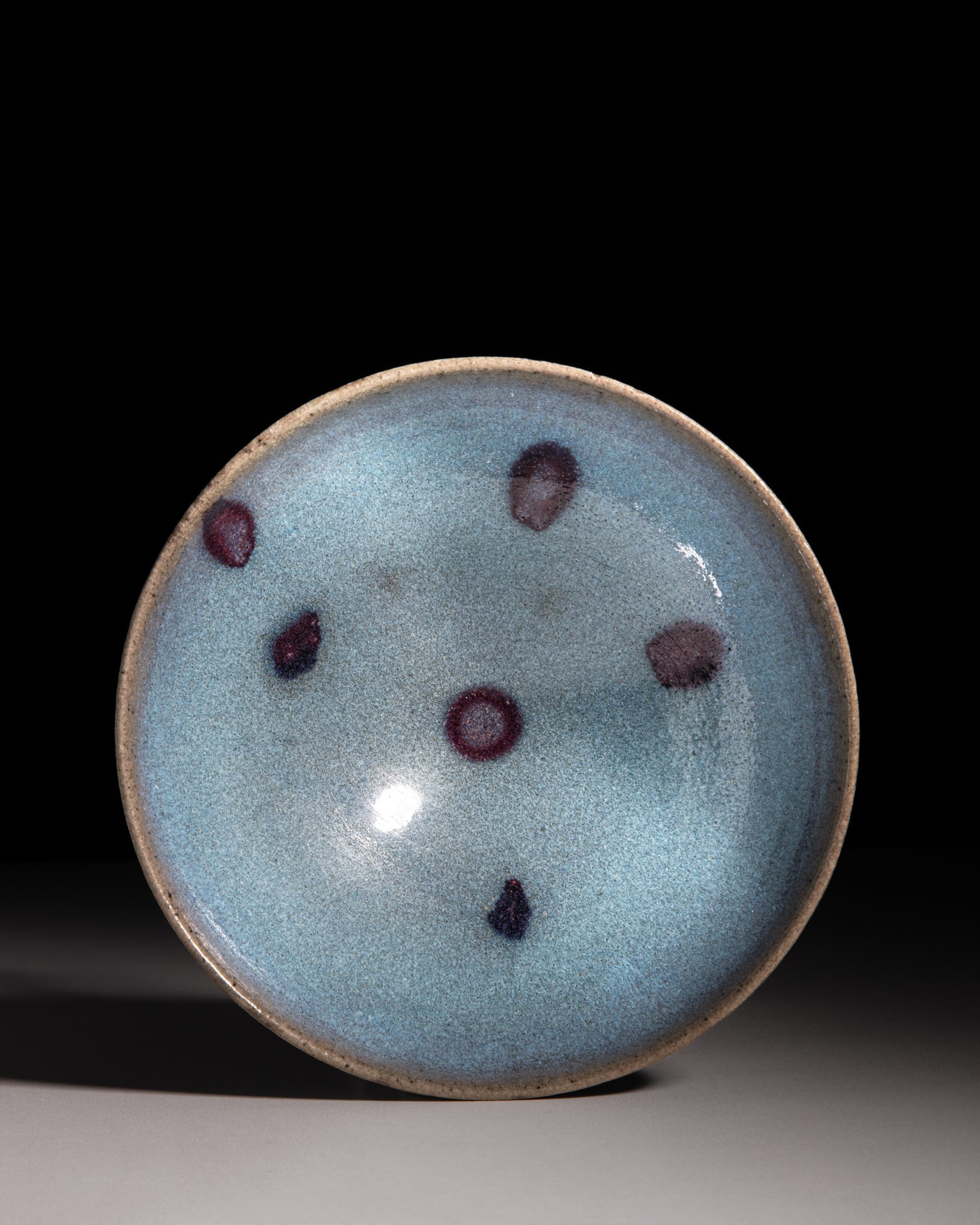 A MYSTERIOUS BLUE AND PURPLE-SPLASHED JUN WARE BOWL 金-元 钧窑‘: A MYSTERIOUS BLUE AND PURPLE-SPLASHED JUN WARE BOWL ?-? ??‘????’? China, Jin-Yuan period (1115-1368) D.18.2cm This Jun ware bowl is covered with a sky-blue glaze that gradually deepens from a pale
