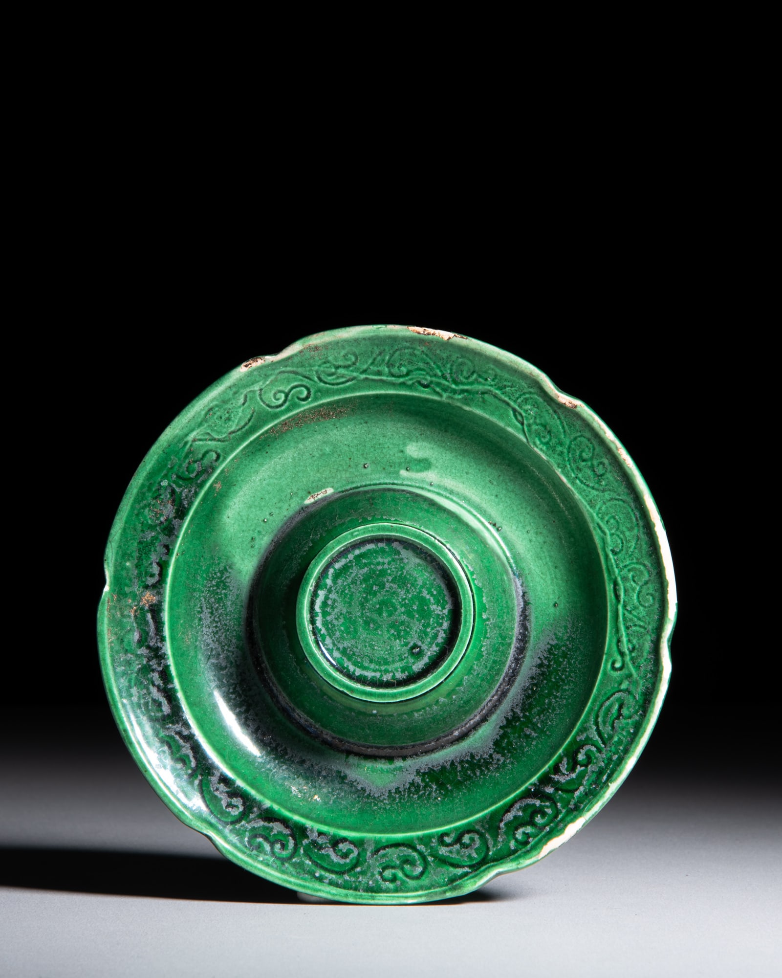 A GREEN-GLAZED MOULDED ‘SCROLLING FOLIAGE’ STEM CUP STAND 宋-元 绿: A GREEN-GLAZED MOULDED ‘SCROLLING FOLIAGE’ STEM CUP STAND 宋-元 绿釉刻卷草纹盏托 China, Song-Yuan dynasty (960-1368) D.12.5cm -