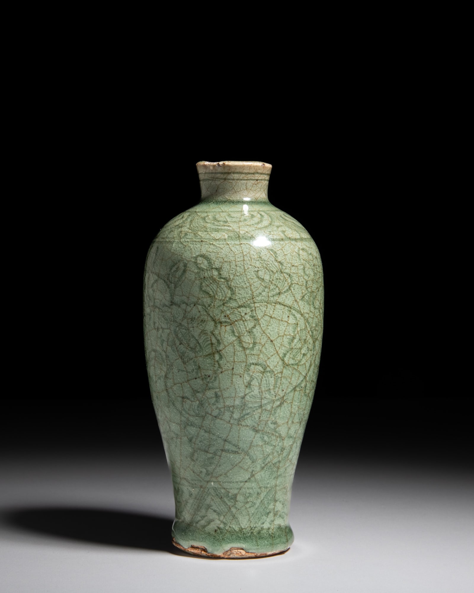 A SMALL CARVED LONGQUAN 'FLOWER' MEIPING 明代 龙泉刻花梅: A SMALL CARVED LONGQUAN 'FLOWER' MEIPING 明代 龙泉刻花梅瓶 China, Ming dynasty H.17.8cm Provenance: A Paris art instructor’s collection