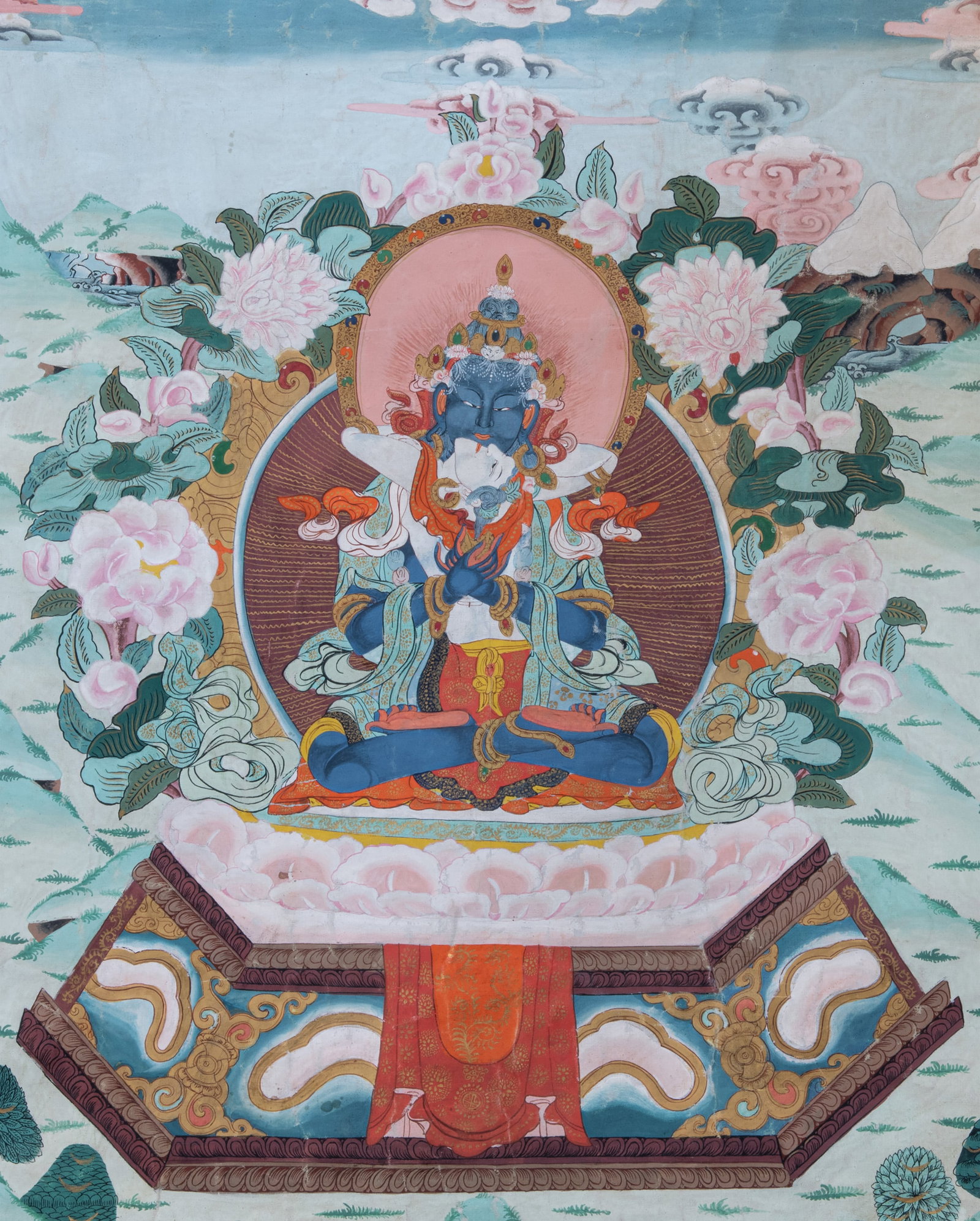 A FINE POLYCHROME AND GILT THANGKA ON CLOTH DEPICTING VAJRADHARA IN YAB-YUM Nepal, 20th Century: A FINE POLYCHROME AND GILT THANGKA ON CLOTH DEPICTING VAJRADHARA IN YAB-YUM Nepal, 20th Century With a gold colour silk brocade framing. At the center of the composition is the Primordial Buddha, Vajr