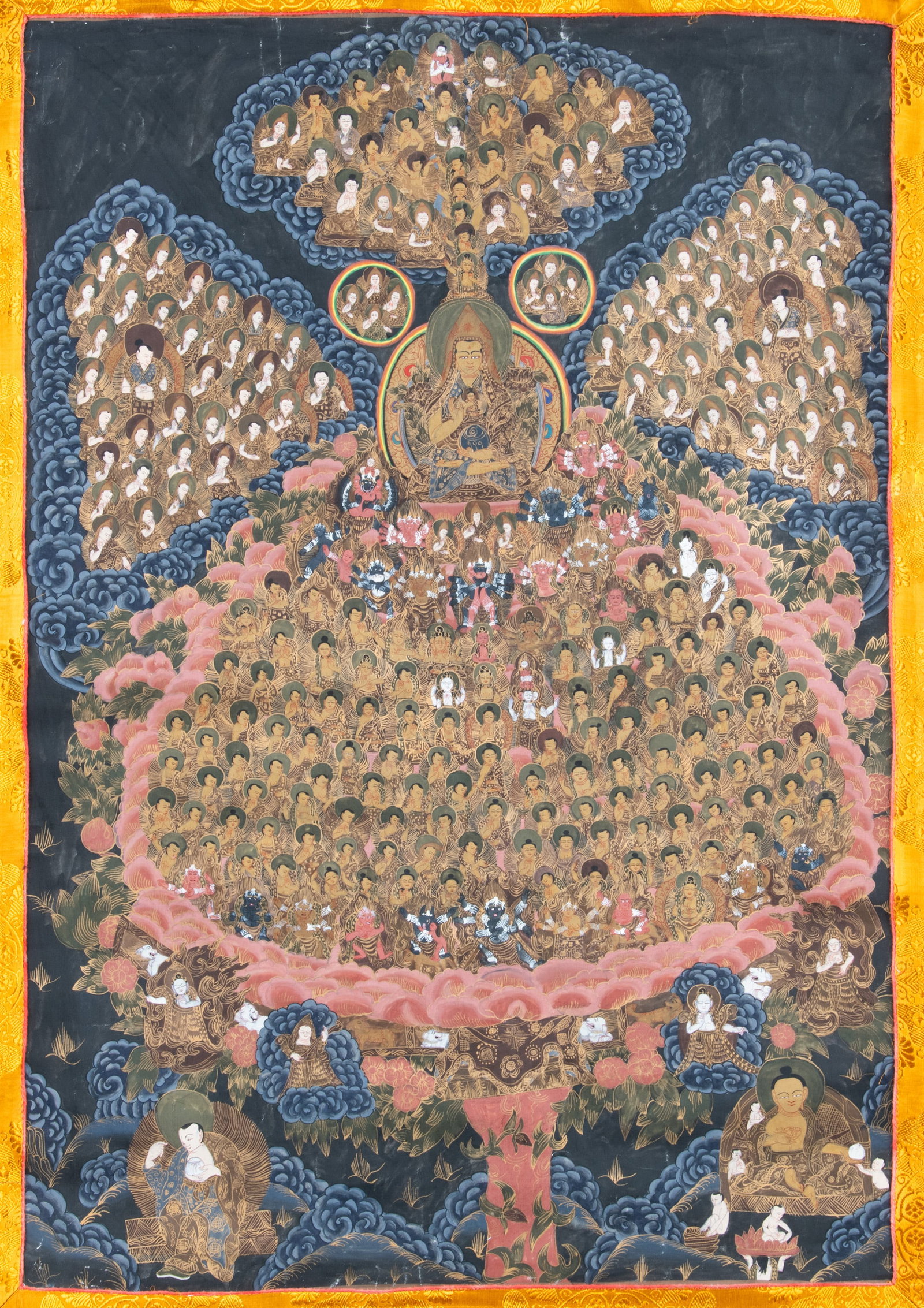 A POLYCHROME AND GILT THANGKA ON BLACK GROUND DEPICTING 'GURU-PARAMPARA' WITH TSONGKHAPA AND THE GEL: A POLYCHROME AND GILT THANGKA ON BLACK GROUND DEPICTING 'GURU-PARAMPARA' WITH TSONGKHAPA AND THE GELUGPA LINEAGE TREE Nepal, 20th Century. With a black silk mount The composition of this striking blac