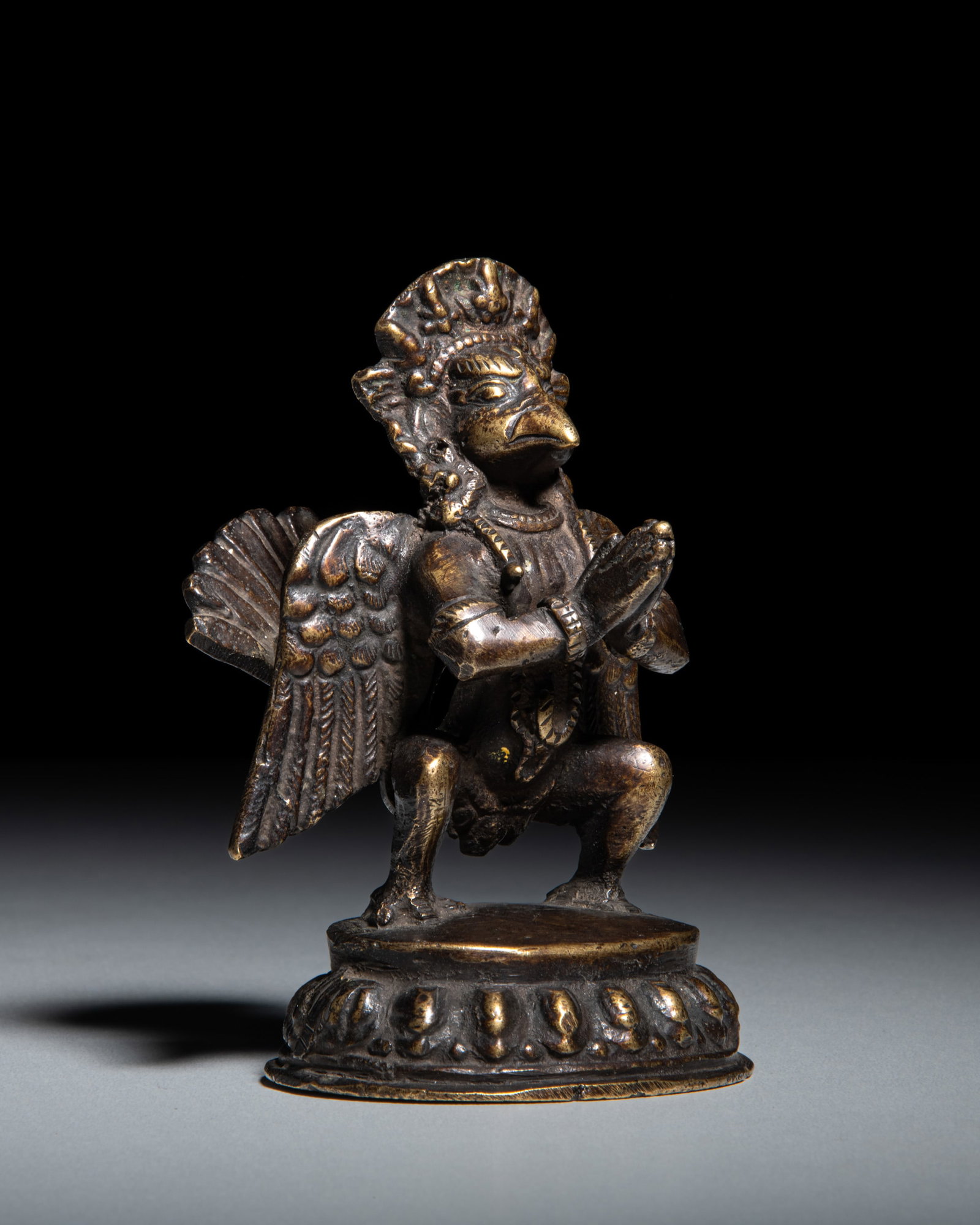 A COPPER ALLOY FIGURE OF A GARUDA Nepal, 20th Century depicts the anthropomorphic bird deity (1 of 3)