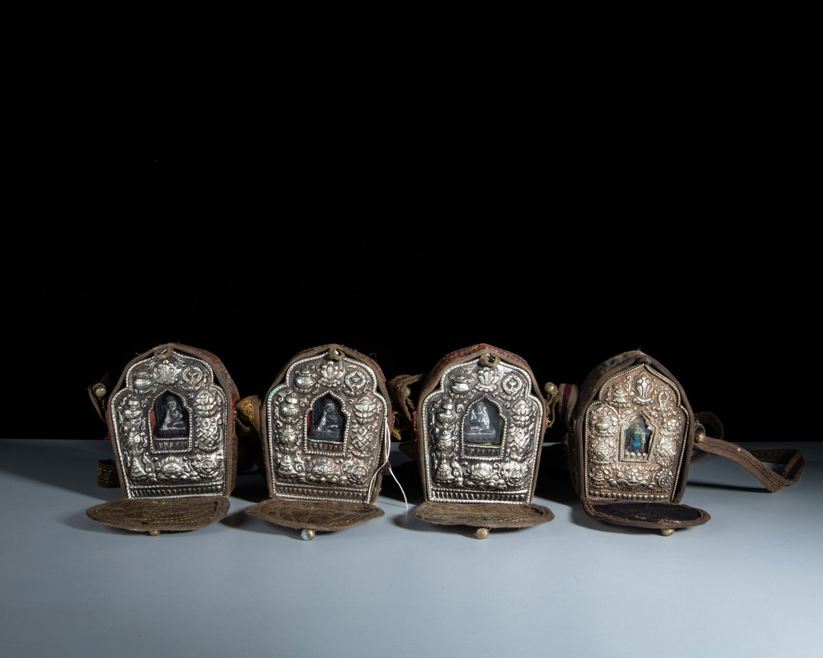 A SET OF FOUR SMALL SHRINE-SHAPED MIXED-METAL GAU BOXES WITH THEIR CONTENTS AND CLOTH COVERS Tibet (1 of 1)