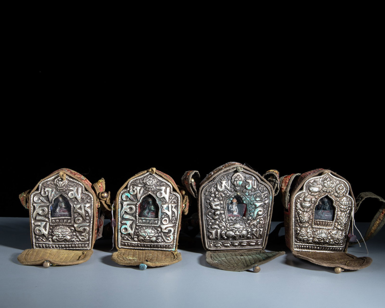 A SET OF FOUR SMALL SHRINE-SHAPED MIXED-METAL GAU BOXES WITH THEIR CONTENTS AND CLOTH COVERS Tibet (1 of 1)