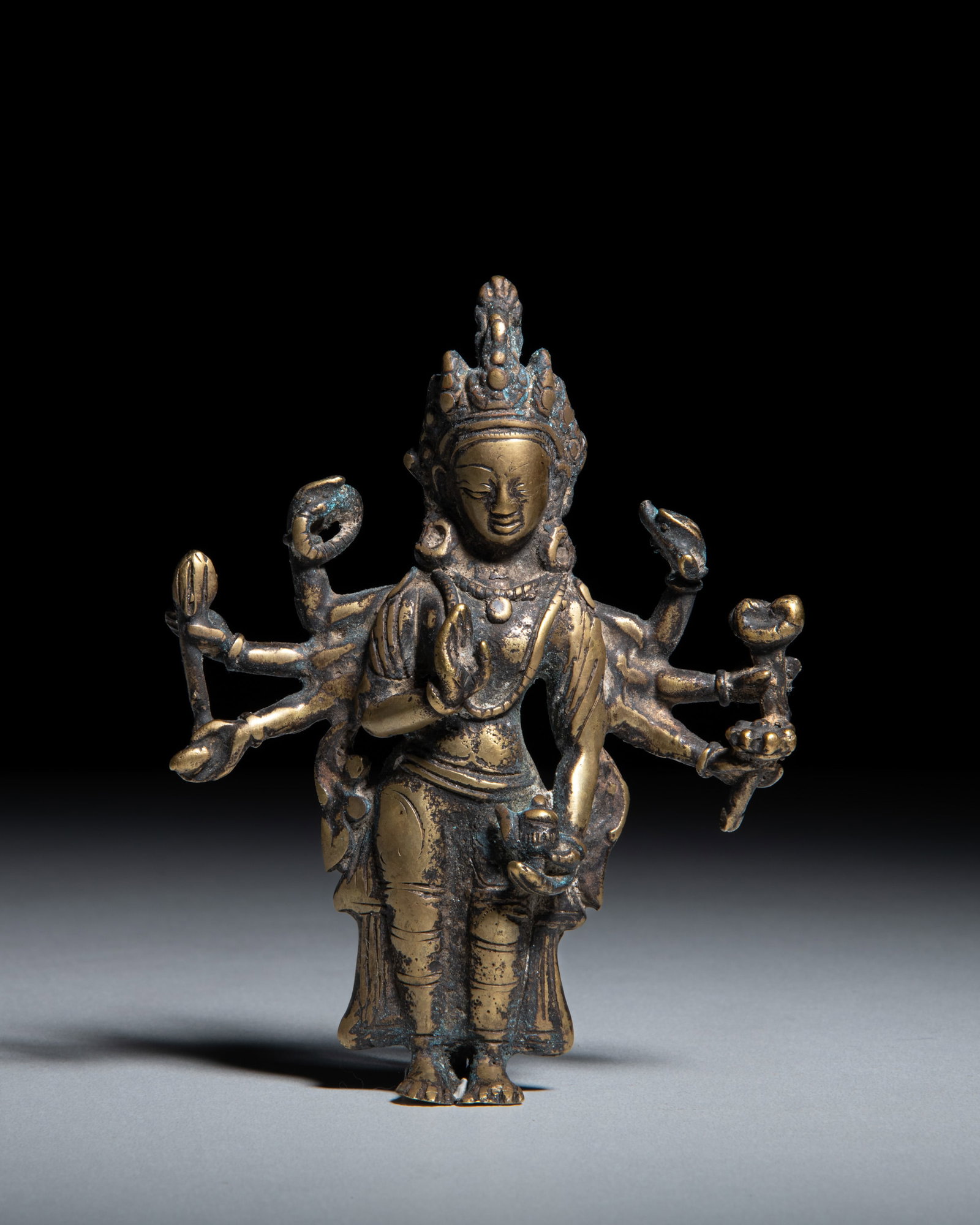 A COPPER ALLOY FIGURE OF AN EIGHT ARMS PADMAPANI Nepal, 20th century depicts Padmapani (a: A COPPER ALLOY FIGURE OF AN EIGHT ARMS PADMAPANI Nepal, 20th century depicts Padmapani (a multi-armed form of Avalokiteshvara, the Bodhisattva of Infinite Compassion) standing in a gentle, elegant tri