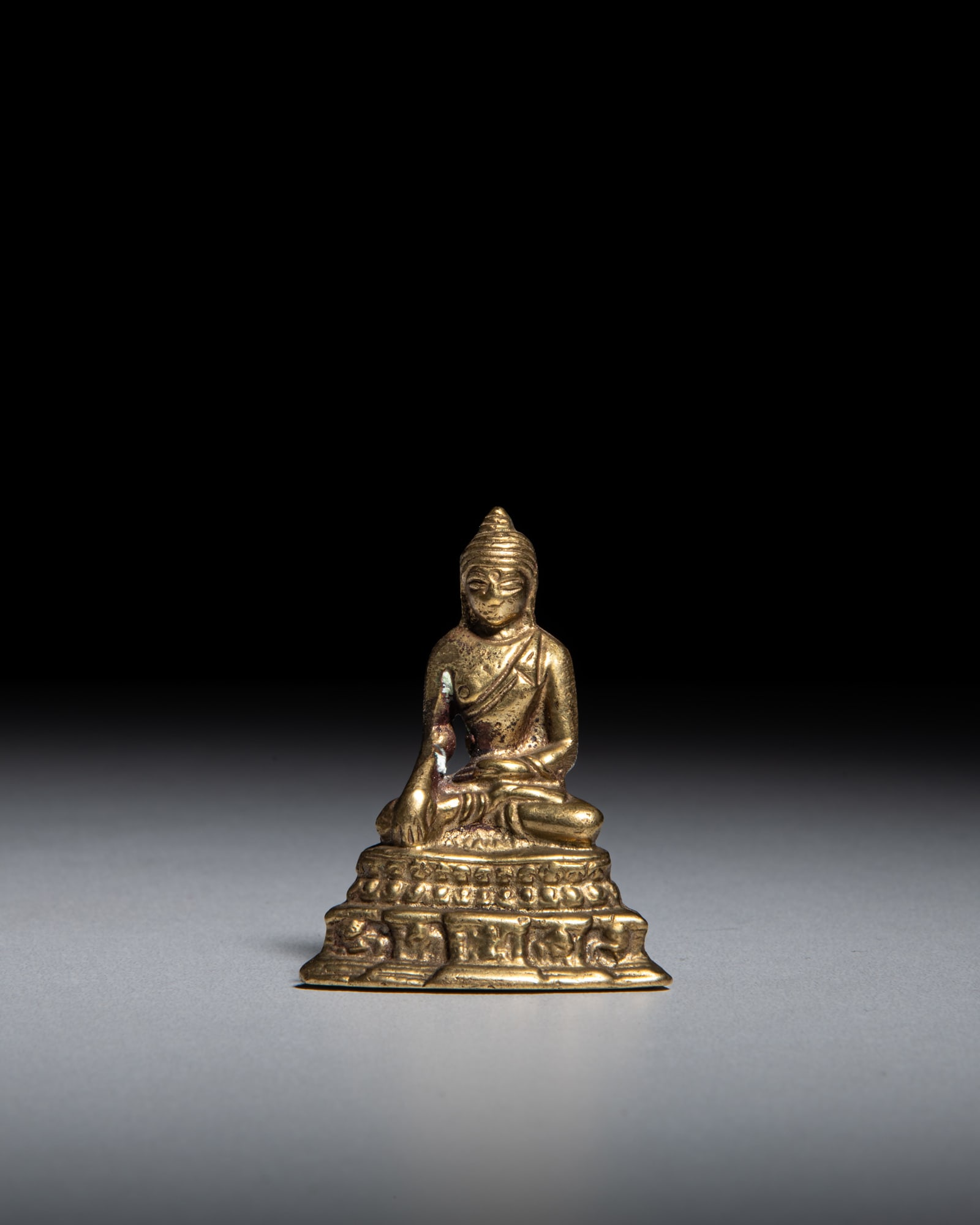 A SMALL GILT COPPER-ALLOY FIGURE OF A BUDDHA Himalayan region, 20th Century depicts Buddha (1 of 3)