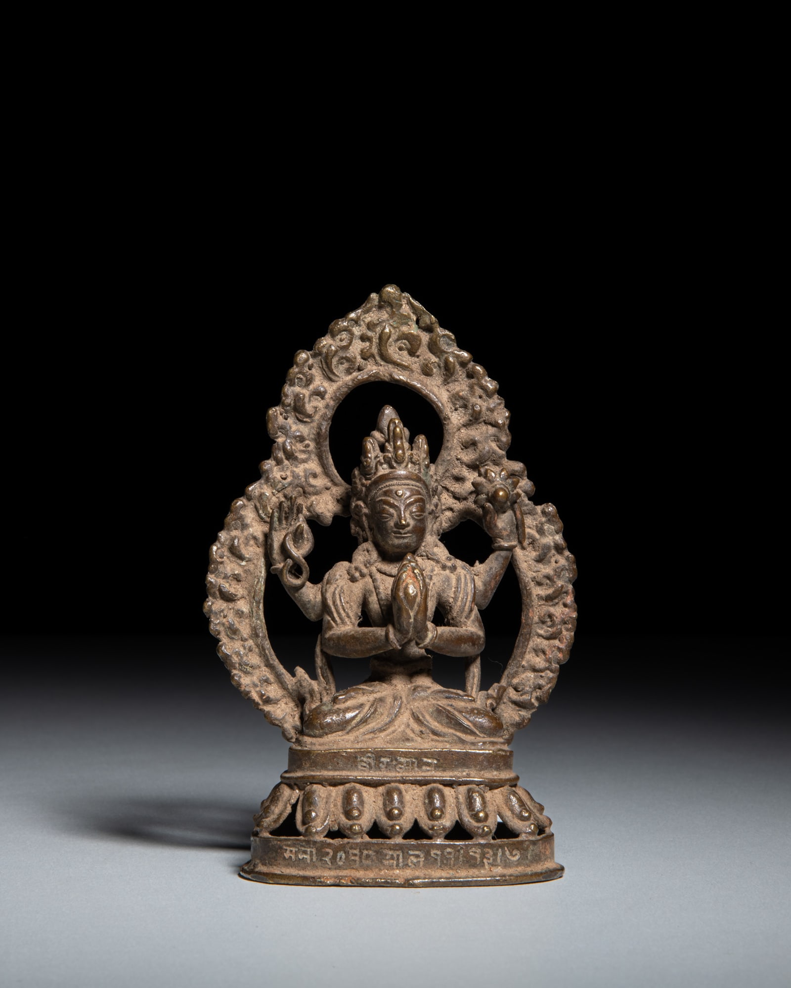 A COPPER ALLOY FIGURE OF SADAKSARI-AVALOKITESHVARA Nepal, circa 1953 depicts: A COPPER ALLOY FIGURE OF SADAKSARI-AVALOKITESHVARA Nepal, circa 1953 depicts Sadaksari-Avalokiteshvara, the four-armed manifestation of the Bodhisattva of Infinite Compassion. He is shown seated in dh