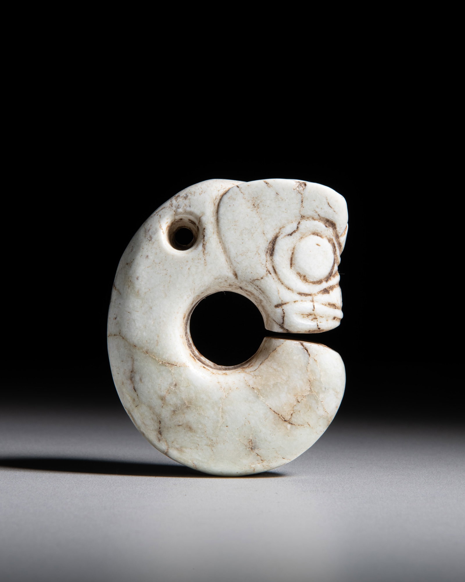 A RARE CALCIFIED JADE ZHULONG ('PIG DRAGON') 红山文化 石化: A RARE CALCIFIED JADE ZHULONG ('PIG DRAGON') 红山文化 石化玉猪龙 China, Hongshan culture (BC4000-BC3000) the iconic coiled body is further accentu
