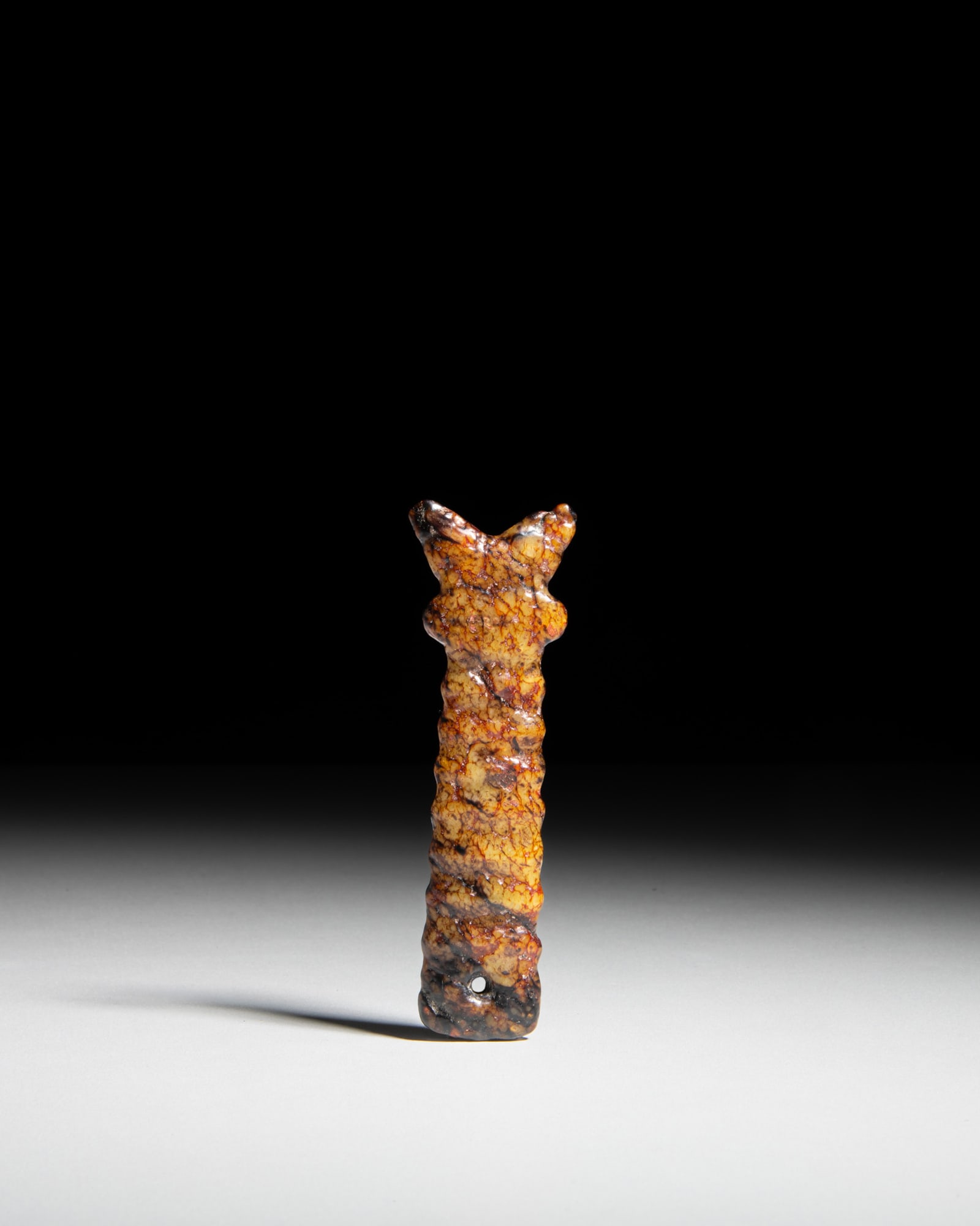 A RARE YELLOW JADE 'SHAMANIC' MASK-FORM Y-SHAPED ORNAMENT China, Hongshan culture, neolithic period (1 of 2)
