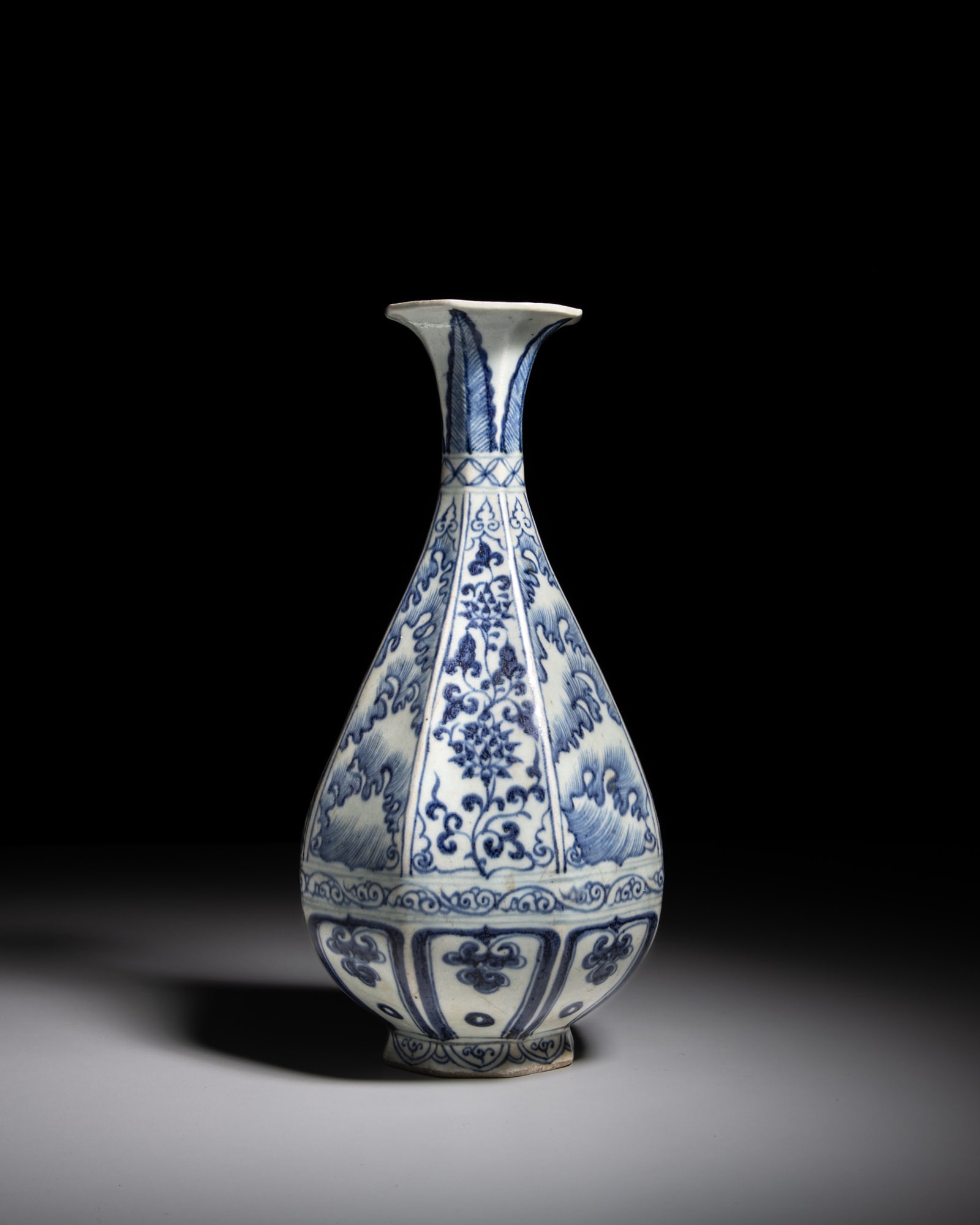 A BLUE AND WHITE FACETED 'FLOWERS AND WAVES' YUHUCHUN VASE 元代风格 ༡: A BLUE AND WHITE FACETED 'FLOWERS AND WAVES' YUHUCHUN VASE 元代风格 青花海水花卉纹八棱玉壶春瓶 Chi