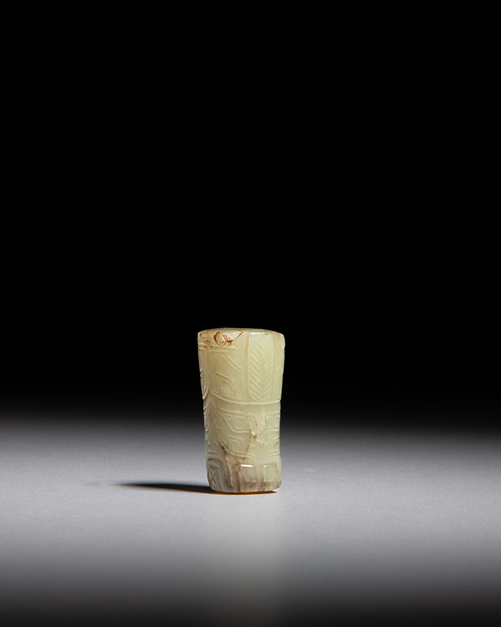 A CELADON JADE SQUARE-SHAPED BEAD WITH BROWNISH RUSSET TAOTIE MASK MOTIF 商代 青&: A CELADON JADE SQUARE-SHAPED BEAD WITH BROWNISH RUSSET TAOTIE MASK MOTIF 商代 青玉带沁色饕餮纹勒子 China, Shang dynasty (c. 1600