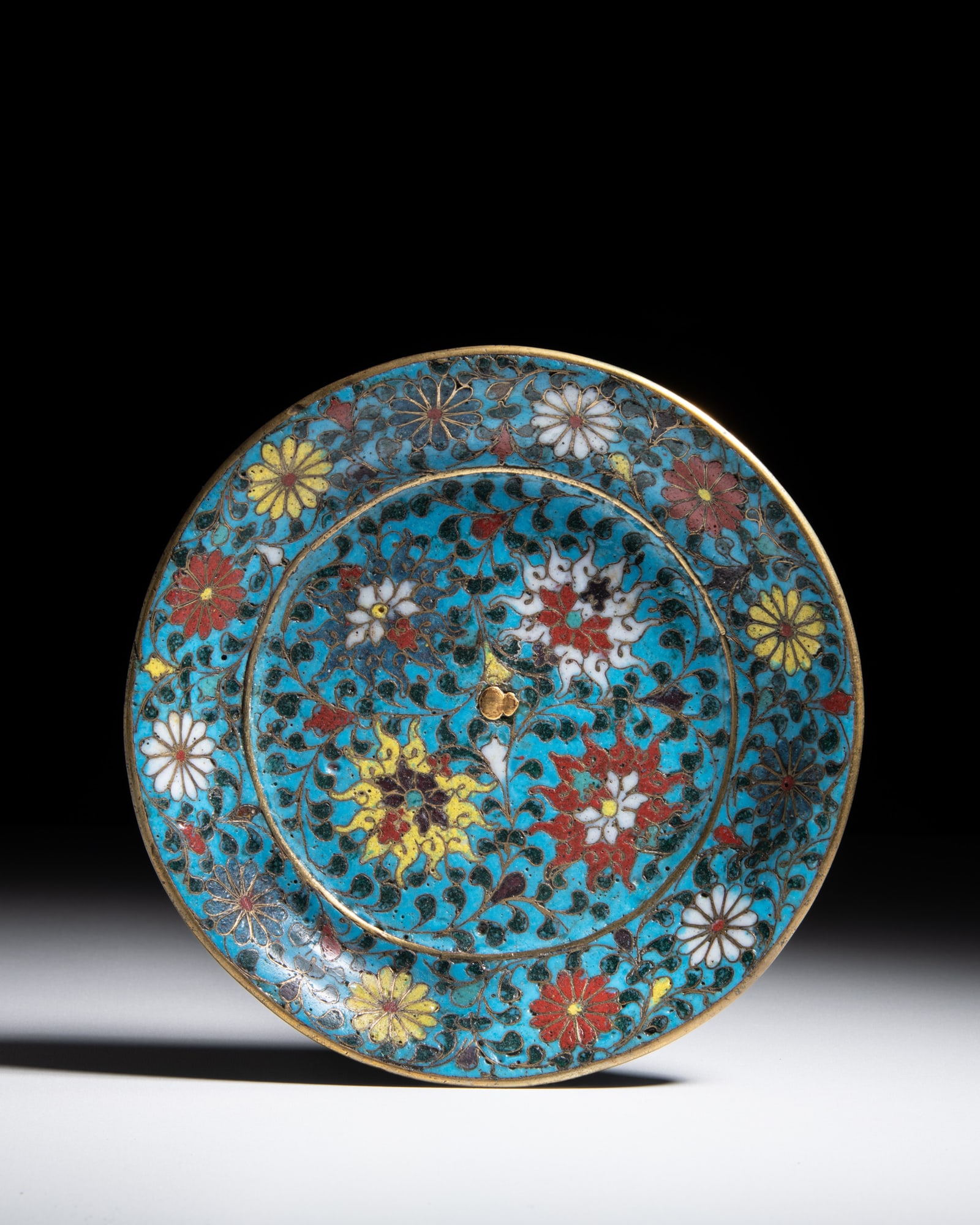 A GILT BRONZE ENAMEL CLOISONNE 'LOTUS AND CHRYSANTHEMUM' DISH 明代 景泰: A GILT BRONZE ENAMEL CLOISONNE 'LOTUS AND CHRYSANTHEMUM' DISH 明代 景泰蓝‘莲、菊’纹盘 China, Ming dynasty D.16.3cm Provenance: P
