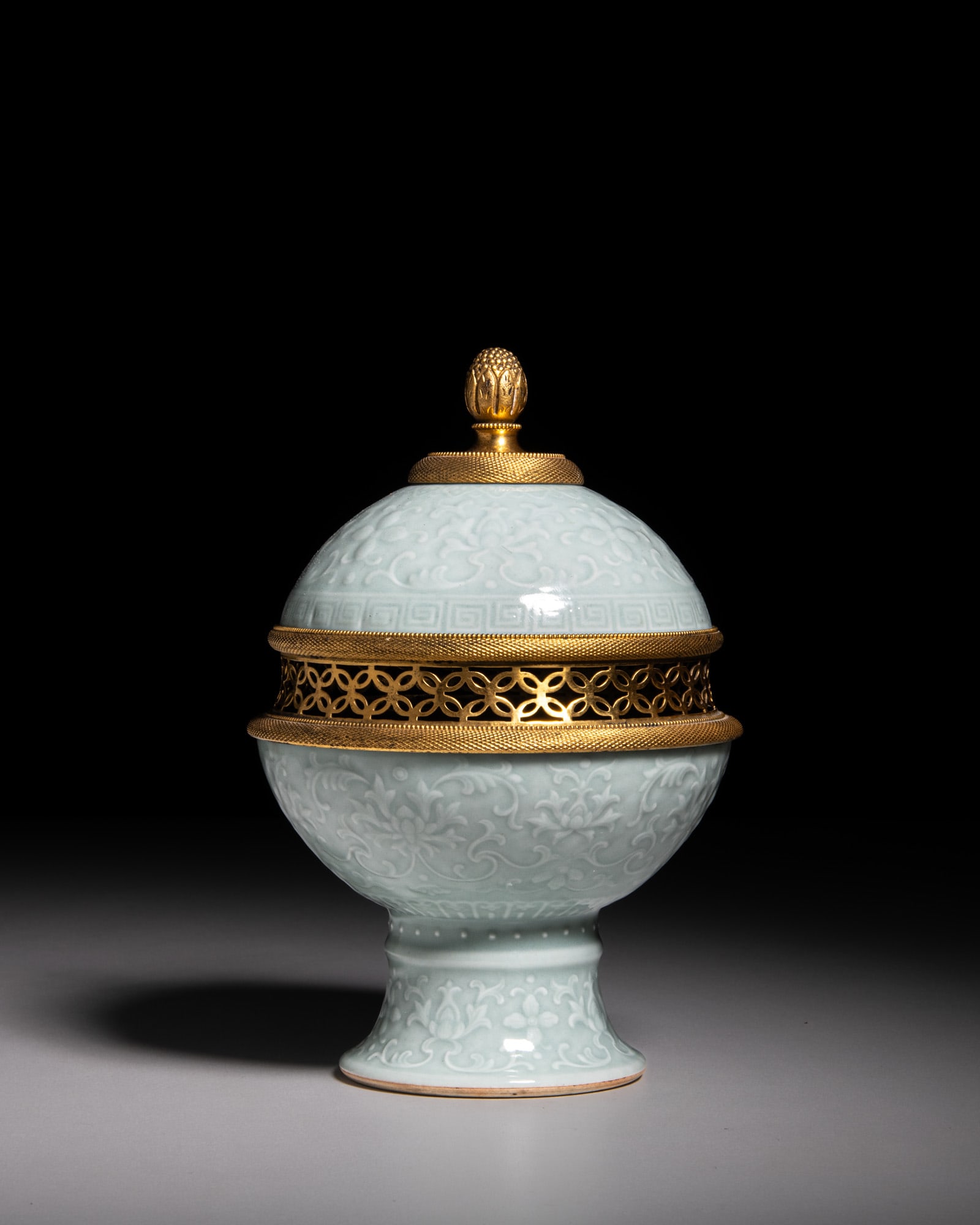 A CARVED CELADON-GLAZED ‘LOTUS’ GLOBULAR STEM URN AND COVER, MARKED QIANLONG ‘: A CARVED CELADON-GLAZED ‘LOTUS’ GLOBULAR STEM URN AND COVER, MARKED QIANLONG ‘大清乾隆年制’六字篆书款