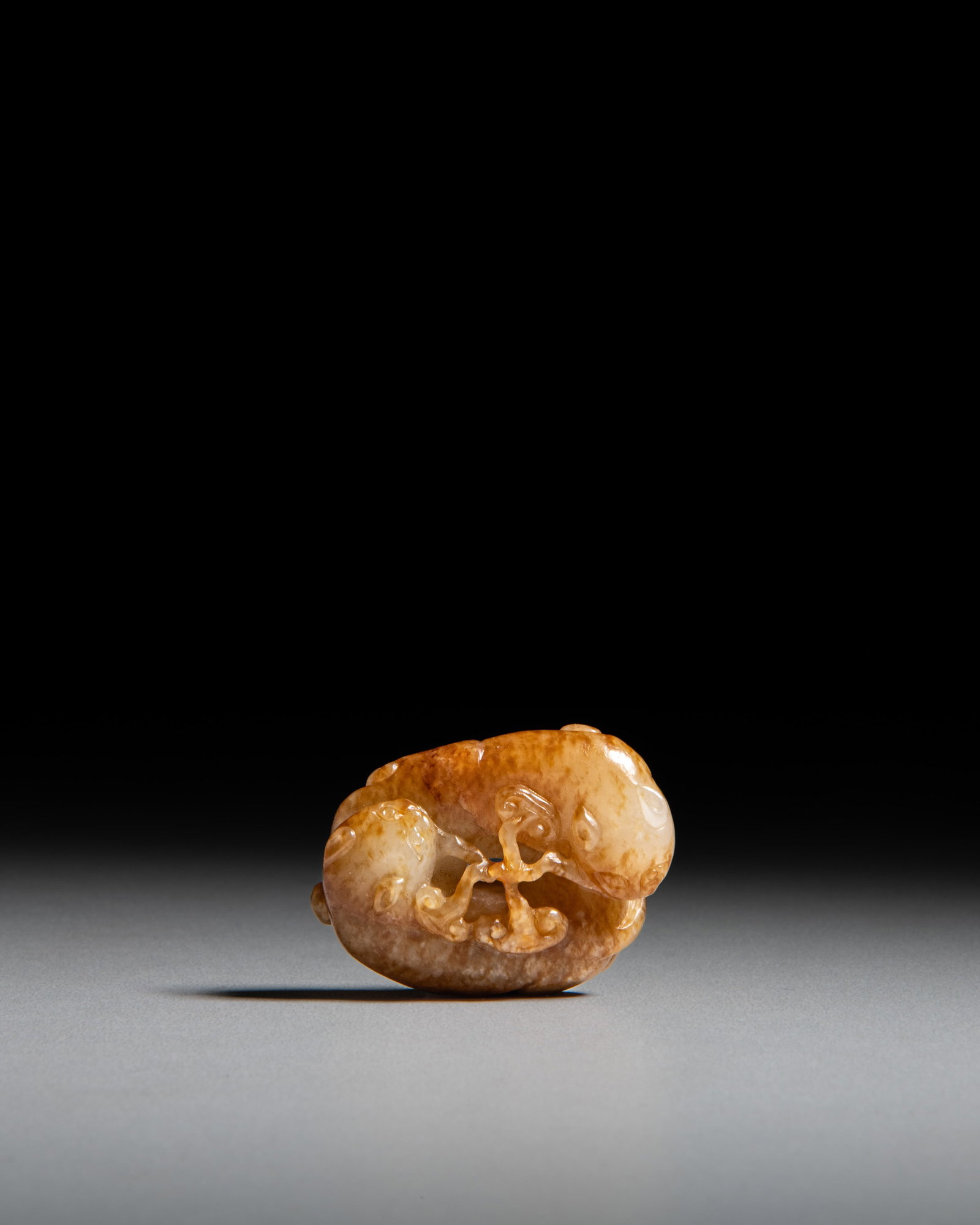 A FINELY RETICULATED WHITE JADE PENDANT WITH BROWNISH-RED RUSSET INCLUSIONS, CARVED AS A PAIR OF (1 of 4)