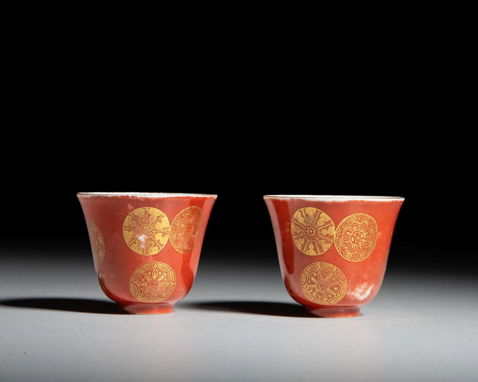 A PAIR OF IRON RED GLAZED GILT 'FLOWER-BALL' CUPS 大清光绪年制: A PAIR OF IRON RED GLAZED GILT 'FLOWER-BALL' CUPS 大清光绪年制款 矾红描金皮球花杯一对 China, Guang