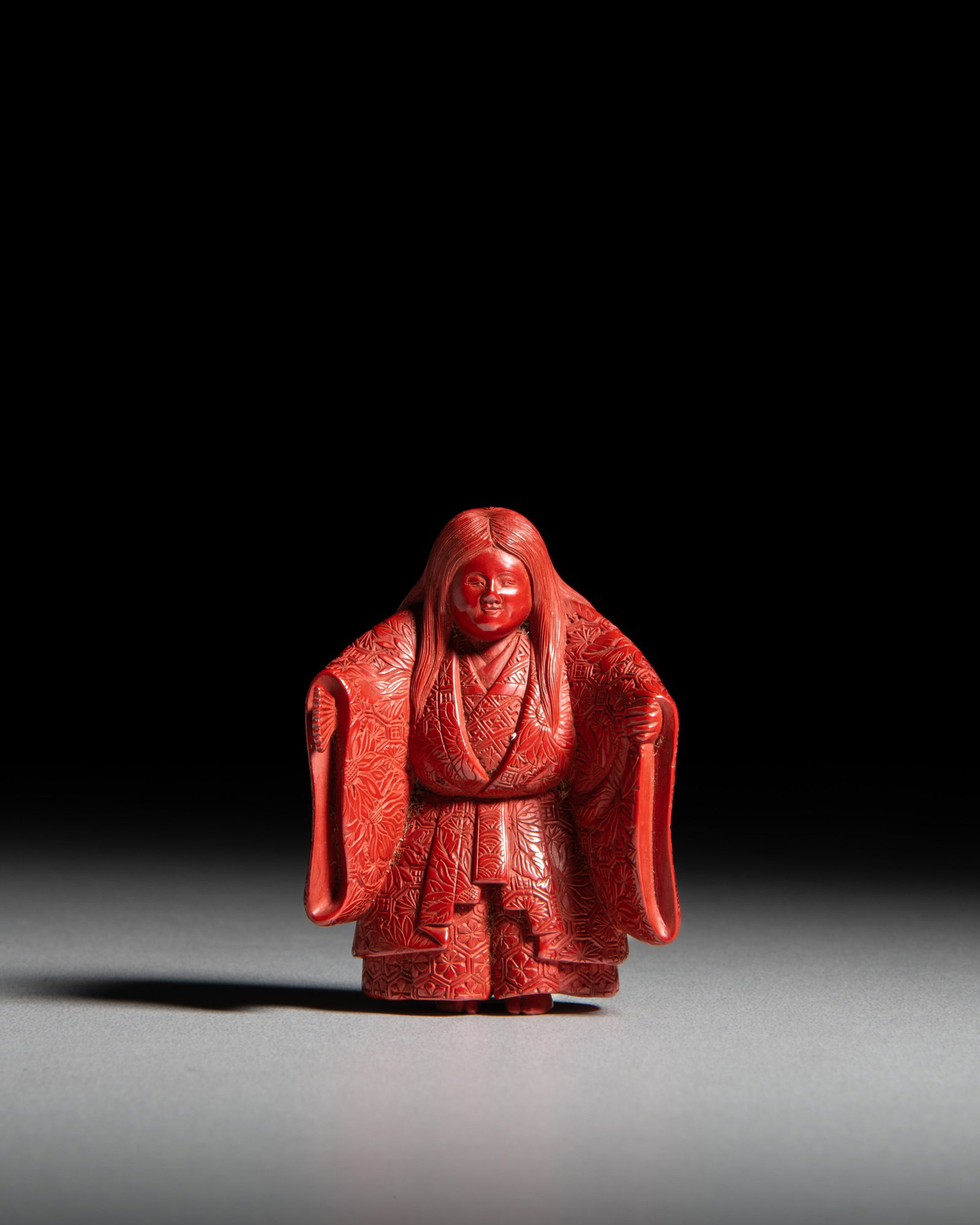 A TSUISHU (CARVED RED-LACQUER) NESUKE OF A SHOJO NOH DANCER Japan, 19th century, late Edo or Meiji (1 of 2)