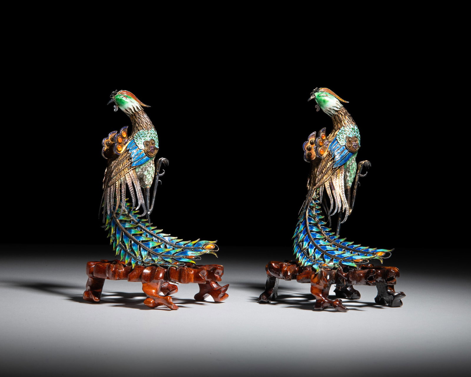 A PAIR OF PARTLY GILT, ENAMELLED FILIGREE SILVER PHOENIXES WITH CARVED WOODEN STANDS 20世: A PAIR OF PARTLY GILT, ENAMELLED FILIGREE SILVER PHOENIXES WITH CARVED WOODEN STANDS 20世纪 银镀金嵌珐琅凤凰摆件一对