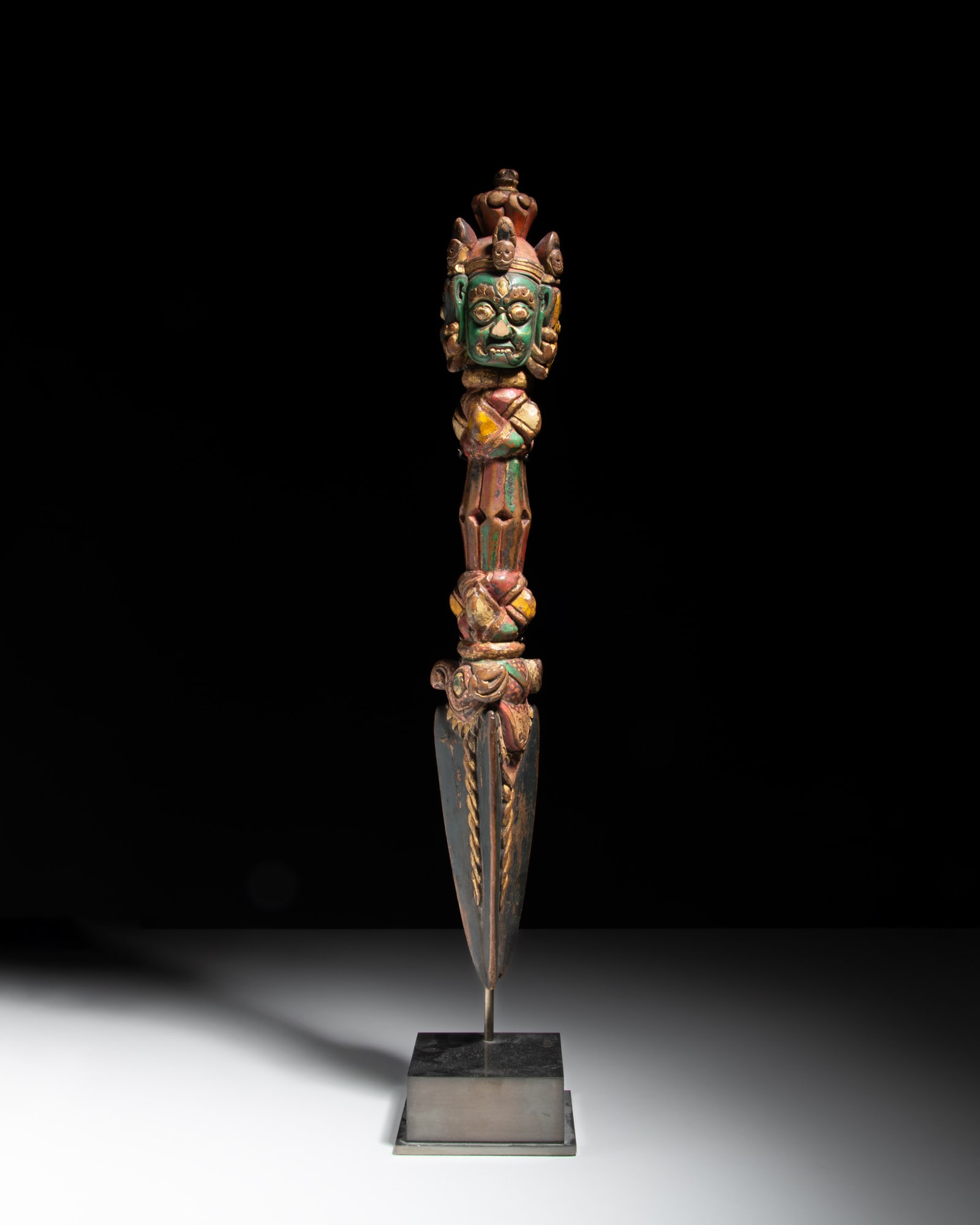 A CARVED WOOD GILT AND POLYCHOME RITUAL PURBHA 西藏 十六世纪: A CARVED WOOD GILT AND POLYCHOME RITUAL PURBHA 西藏 十六世纪 木雕加彩普巴杵 Tibet, 16th century This painted wooden phurba