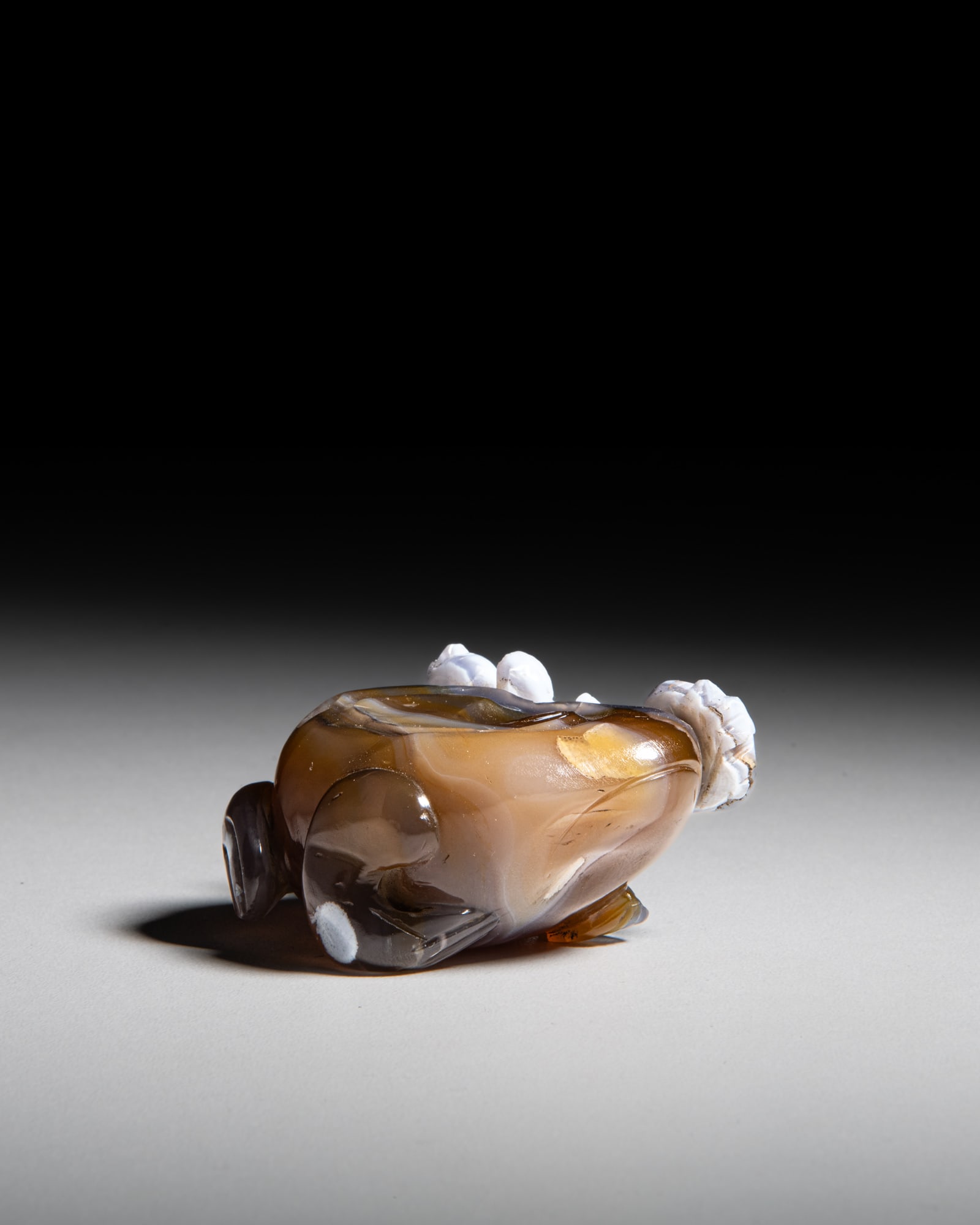 A CARVED TWO-COLOUR AGATE PAPERWEIGHT IN THE FORM OF A FROG 清代 巧雕 (1 of 3)