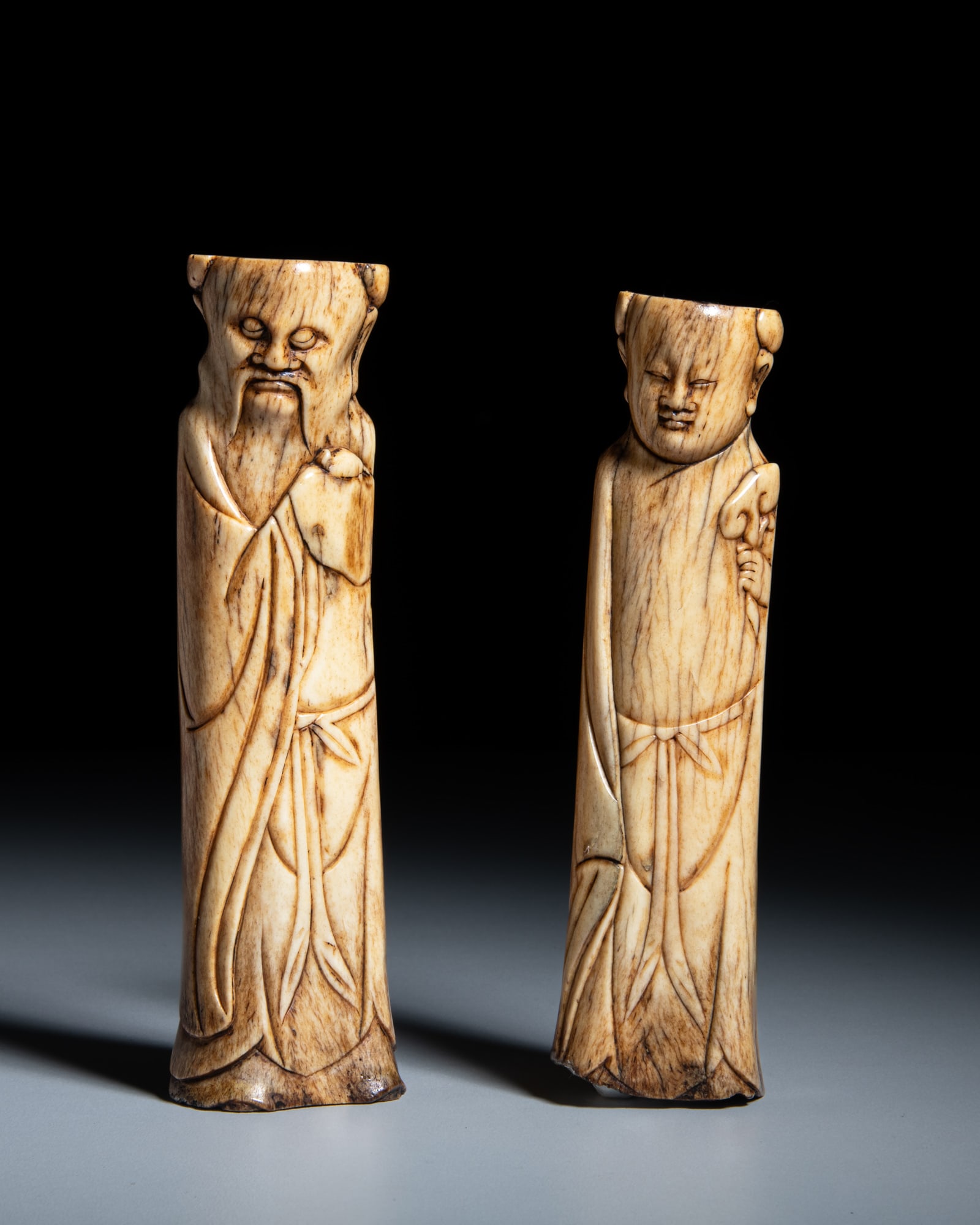 TWO BONE CARVED FIGURES OF DAOIST IMMORTALS 明代 骨雕道教: TWO BONE CARVED FIGURES OF DAOIST IMMORTALS 明代 骨雕道教人物 China, Ming dynasty H.14.5-15.5cm Provenance: A Paris art instructor’s collection No