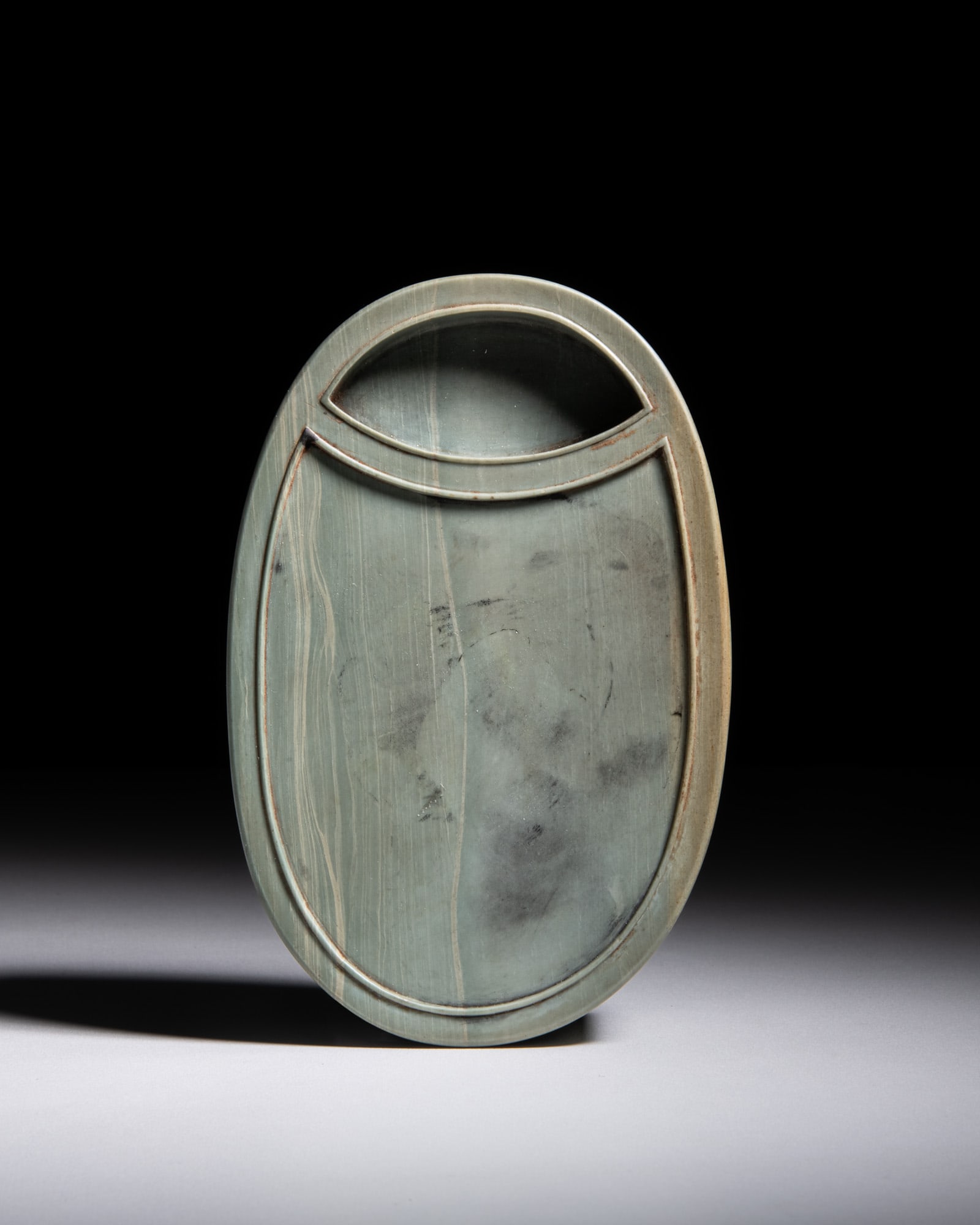 A RARE OVAL SONGHUA INKSTONE INSCRIBED WITH IMPERIAL POETRY, ENTITLED ‘INKSTONE IMITATING HAN: A RARE OVAL SONGHUA INKSTONE INSCRIBED WITH IMPERIAL POETRY, ENTITLED ‘INKSTONE IMITATING HAN DYNASTY ROOF TILE FROM WEI-YANG PALACE’ 清乾隆 松花石'