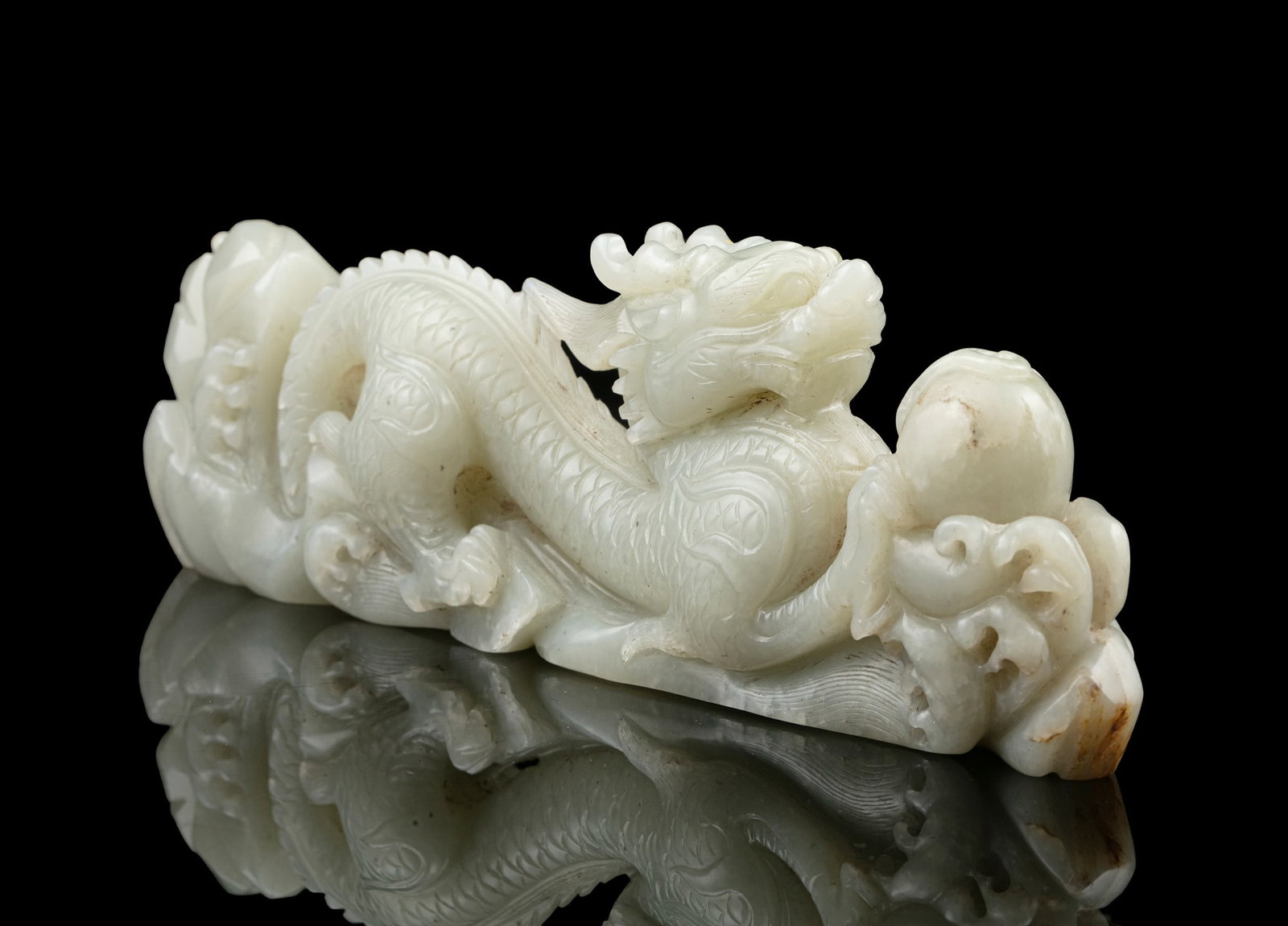 A DECORATIVE 'DRAGON CHASING THE PEARL' JADE BRUSH REST 20世纪 玉龙笔: A DECORATIVE 'DRAGON CHASING THE PEARL' JADE BRUSH REST 20世纪 玉龙笔架 China H: 6 cm - L: 19 cm - depth: 3 cm *This lot is sold without a reserve