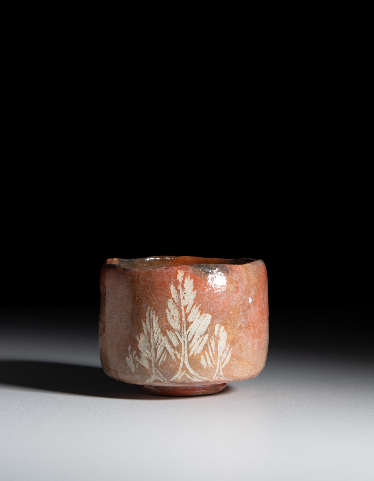 A RED POTTERY 'LEAVES' CHAWAN Signed “Kenzan Go tsukuru” (乾山呉: A RED POTTERY 'LEAVES' CHAWAN Signed “Kenzan Go tsukuru” (乾山呉造) Japan, 19th century With straight sides and a flat base on a small foot, made of stoneware cover