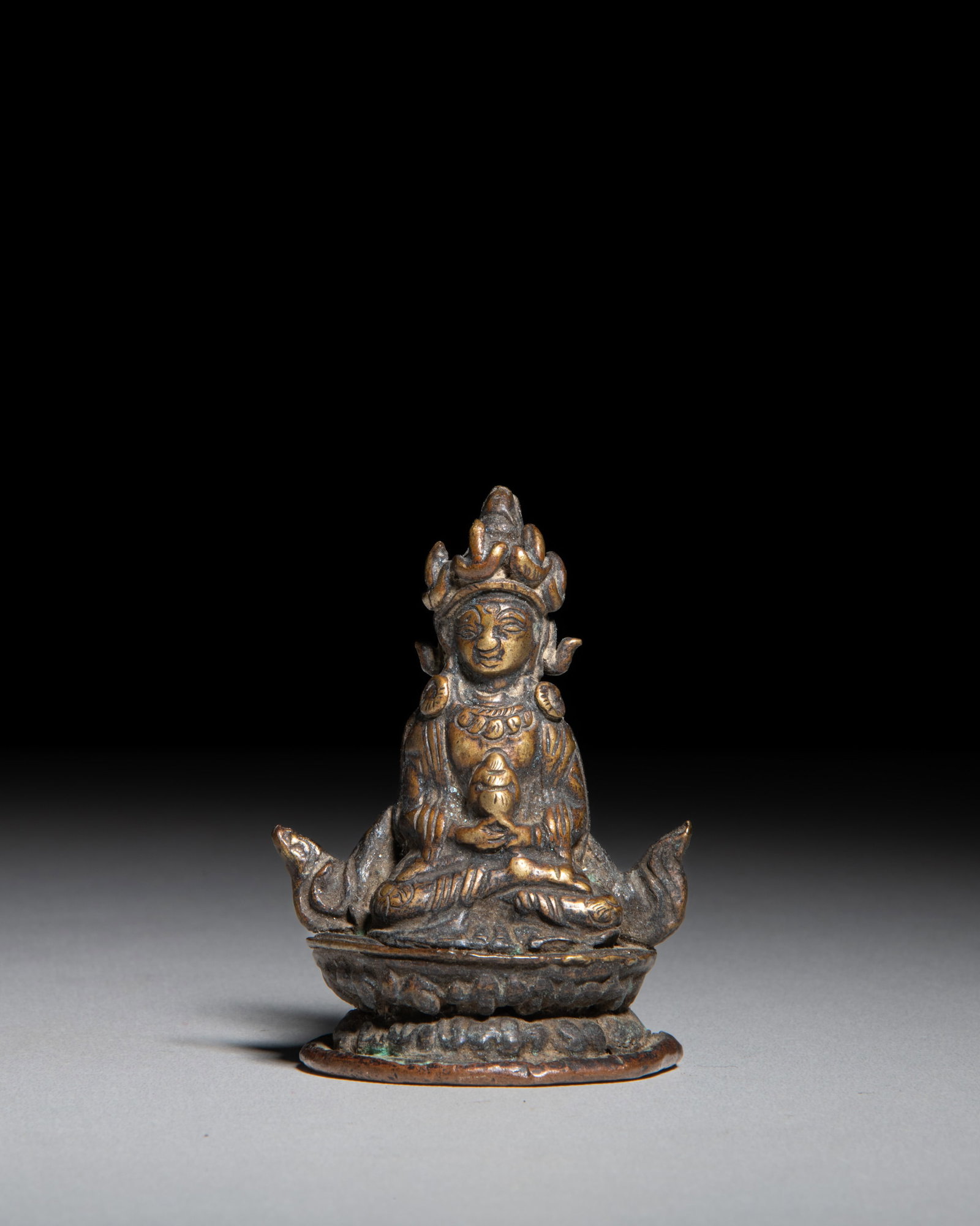 A SMALL BRONZE FIGURE OF AMITAYUS HOLDING THE KALASA Nepal-Tibet, 19th Century Seated on a double- (1 of 3)