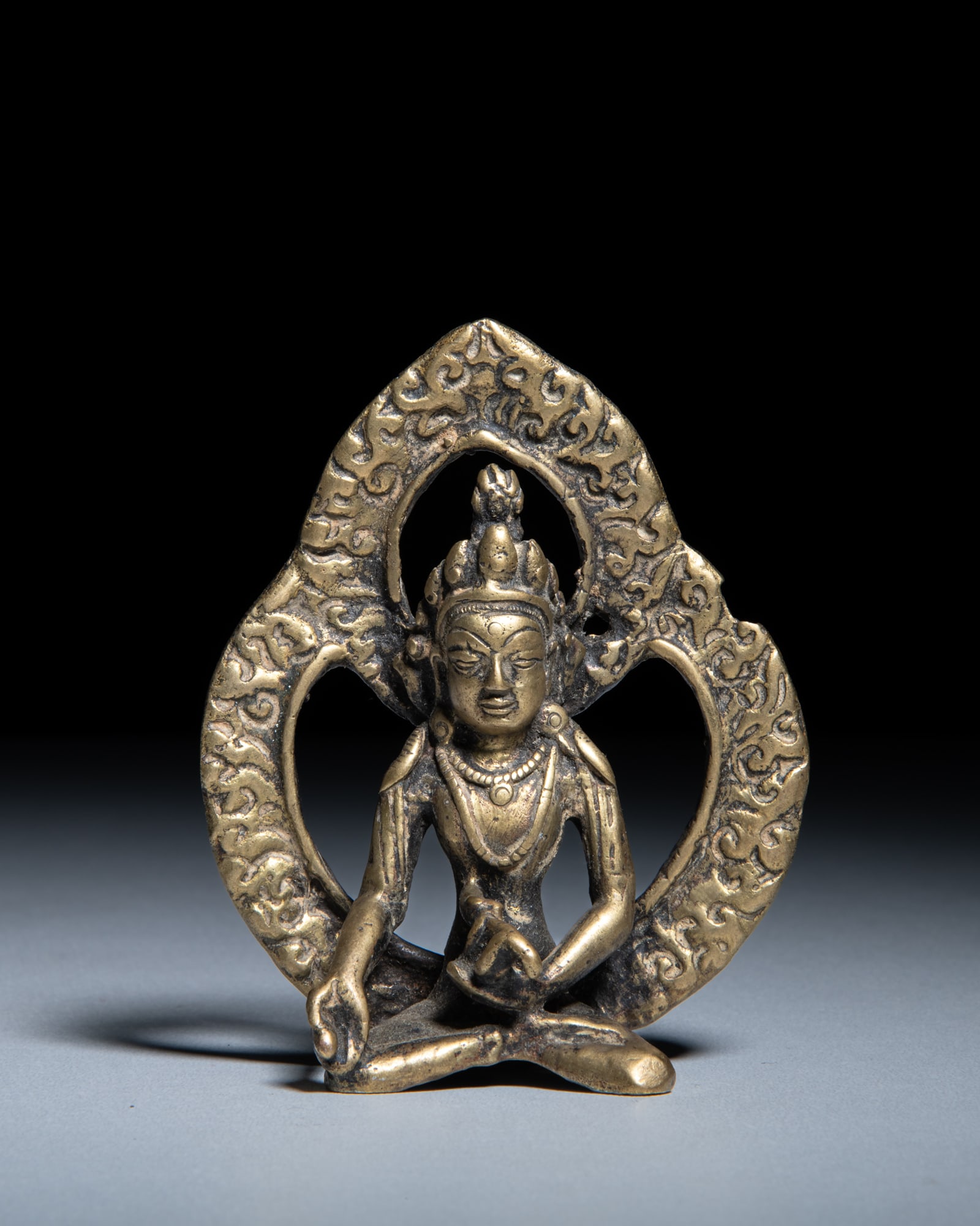 A SMALL BRONZE BODHISATTVA Nepal-Tibet, 19-20th Century depicts a Bodhisattva seated in dhyanasana: A SMALL BRONZE BODHISATTVA Nepal-Tibet, 19-20th Century depicts a Bodhisattva seated in dhyanasana (meditative posture). His right hand is extended downward over his knee in varada-mudra (the boon-gra