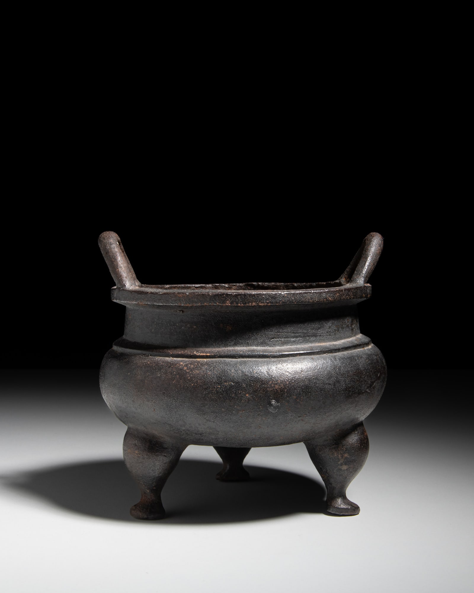 A CAST IRON TRIPOD INCENSE BURNER, MARK XUANDE 清代 宣德款 铸&: A CAST IRON TRIPOD INCENSE BURNER, MARK XUANDE 清代 宣德款 铸铁三足鼎 China, Qing dynasty H.15.5cm