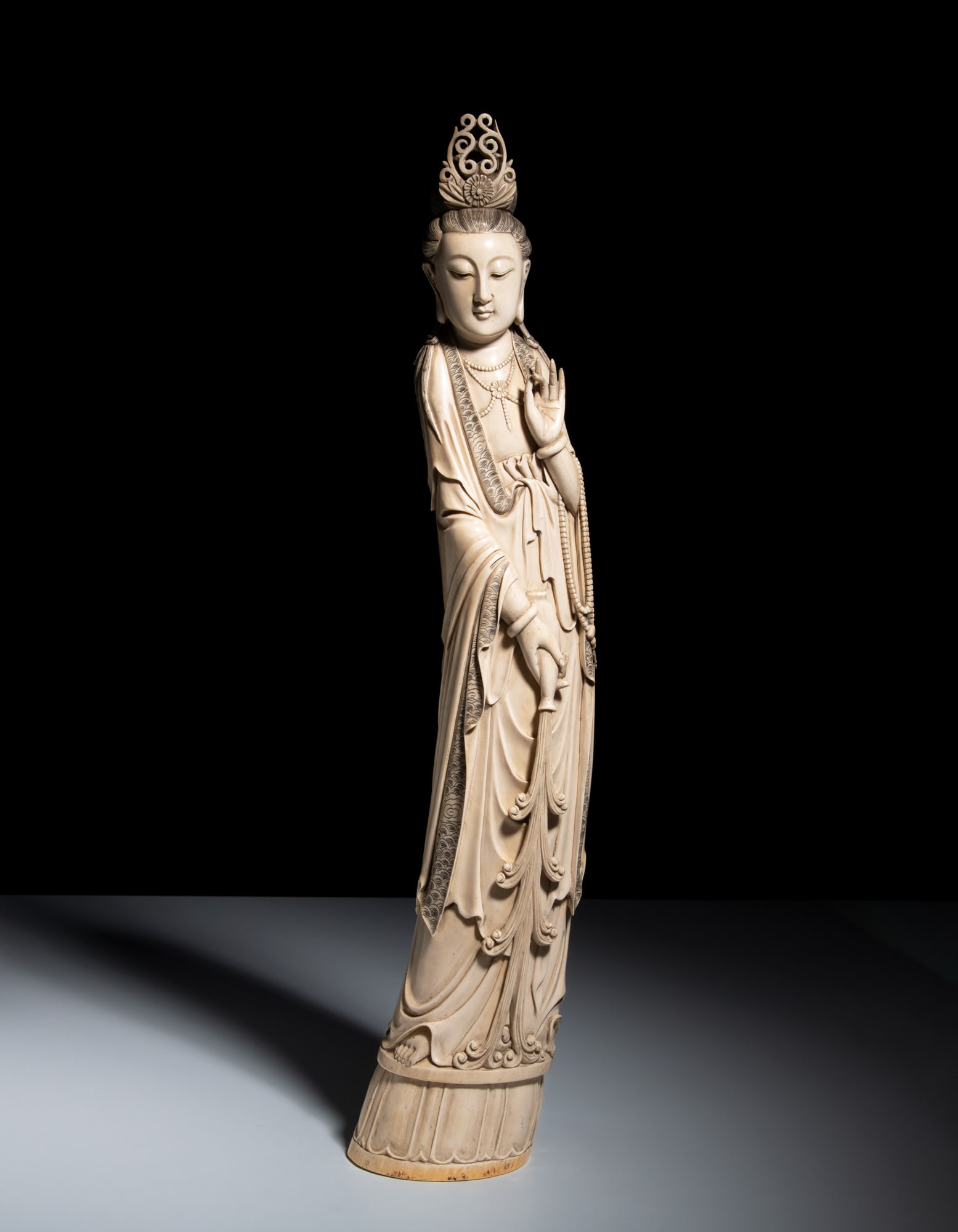 *A FINELY CARVED STANDING GUANYIN POURING SACRED WATER 20世纪初 牙雕&: *A FINELY CARVED STANDING GUANYIN POURING SACRED WATER 20世纪初 牙雕观音立像 China, early 20th century H.64cm