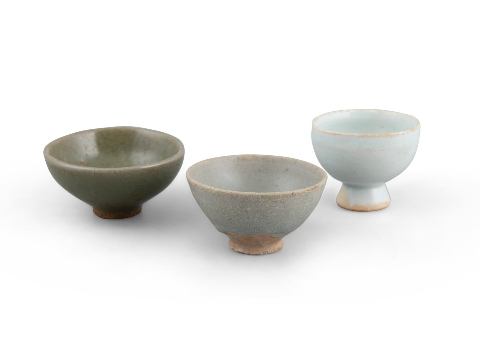 A GROUP OF THREE CELADON GLAZED CERAMIC CUPS 宋-元 青釉杯三: A GROUP OF THREE CELADON GLAZED CERAMIC CUPS 宋-元 青釉杯三件 China, Song-Yuan H.4-5cm - D.6.2-8cm Provenance: From a private collection in Edinburgh